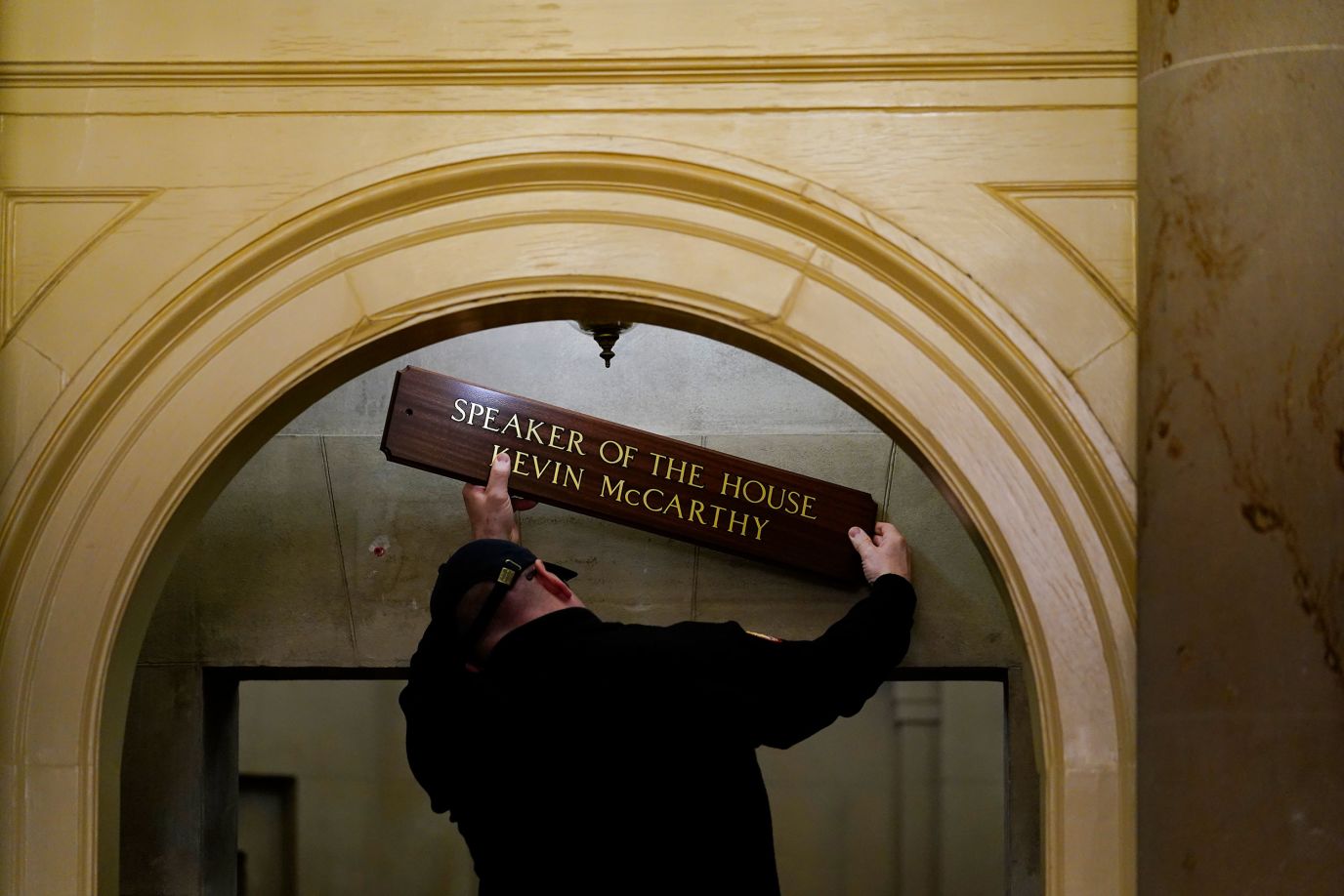 A worker replaces a sign over McCarthy's office on Saturday. 