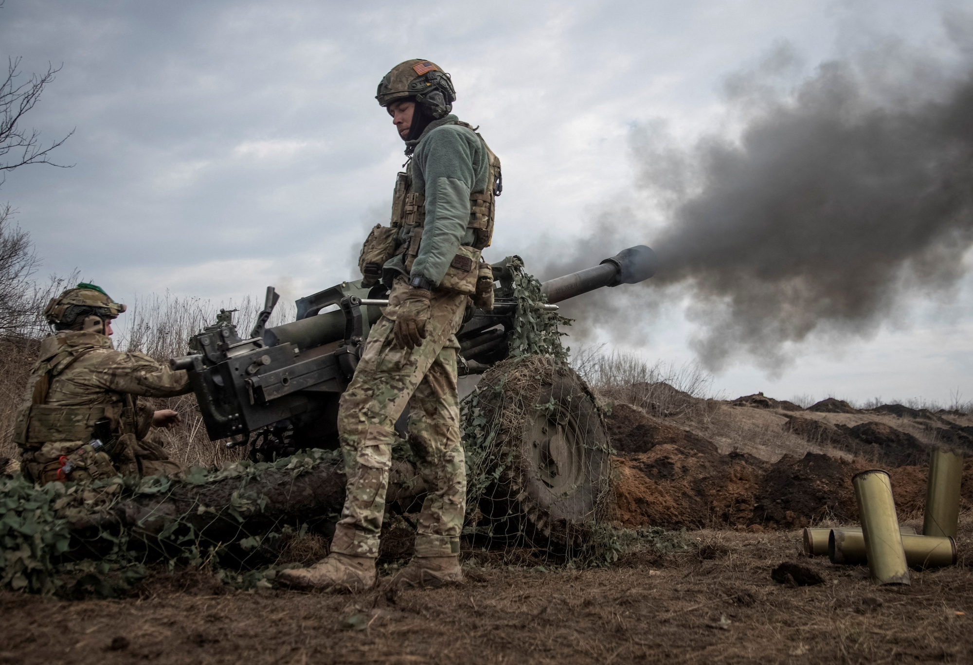 Ukrainian service members fire a howitzer M119 at a front line near the city of Bakhmut on March 10.