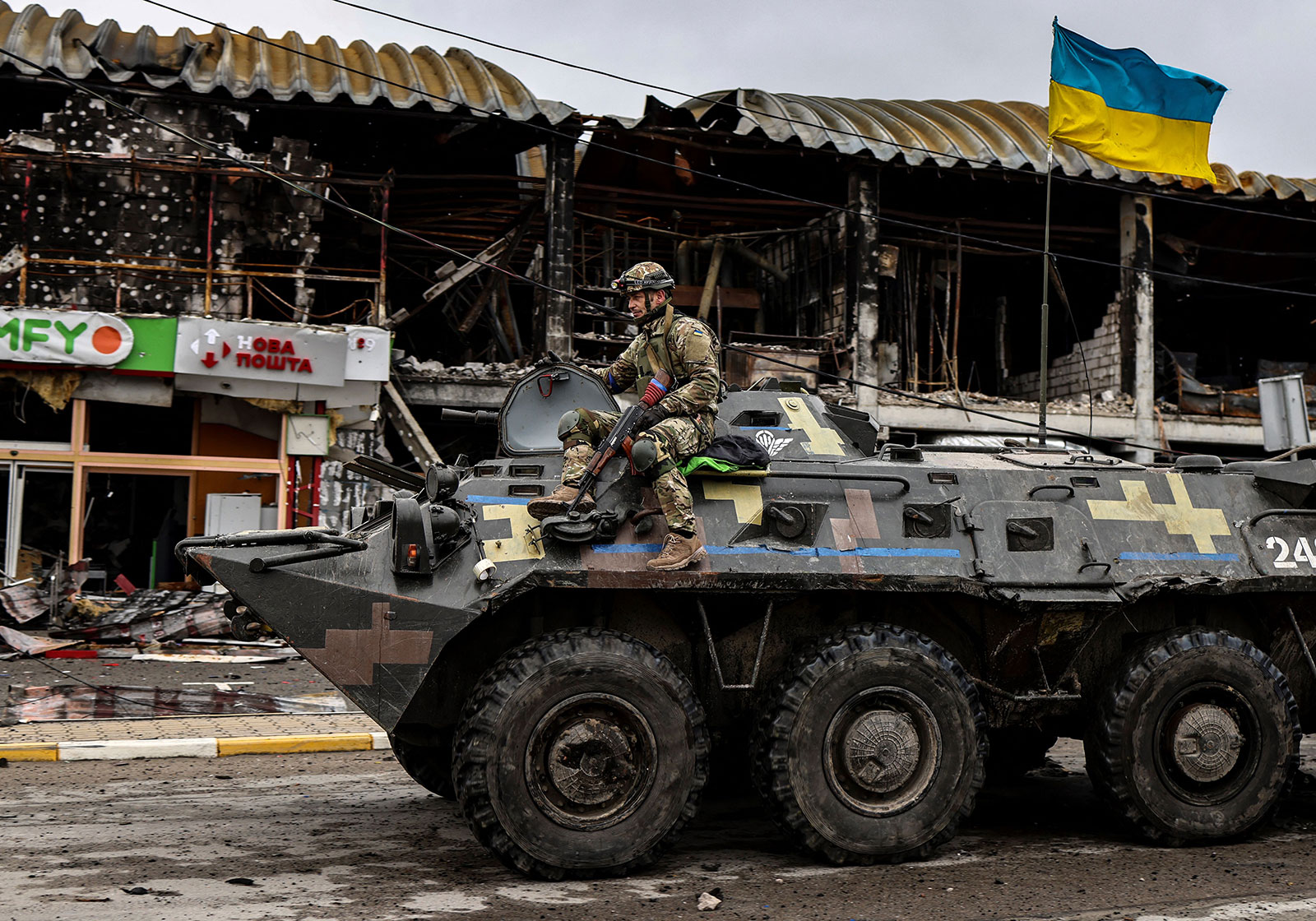 A Ukrainian soldier patrols a street in the town of Bucha in an armored vehicle on April 2.