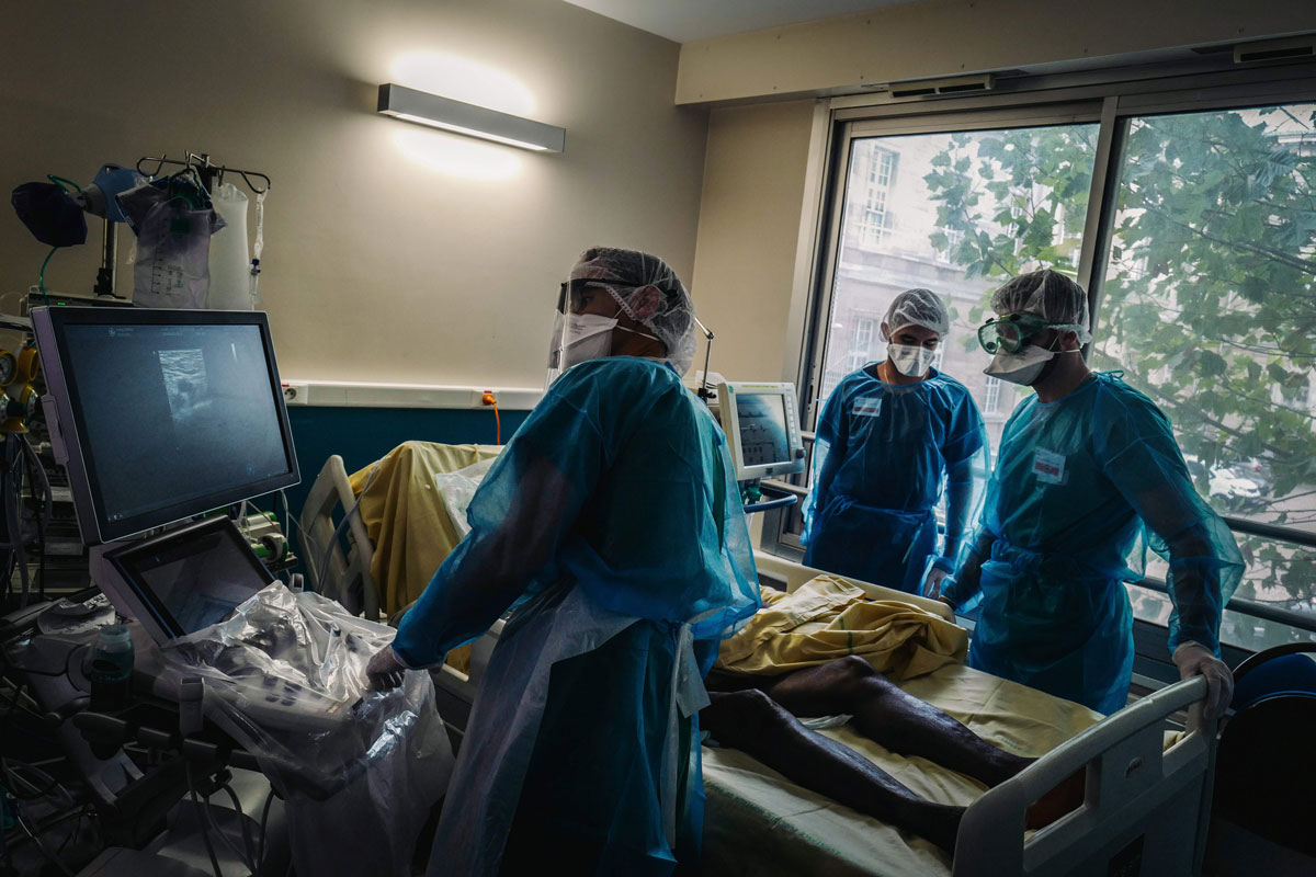 Medical staff members transport a patient infected with COVID-19 at the intensive care unit of Lariboisiere Hospital in Paris, on October 14.