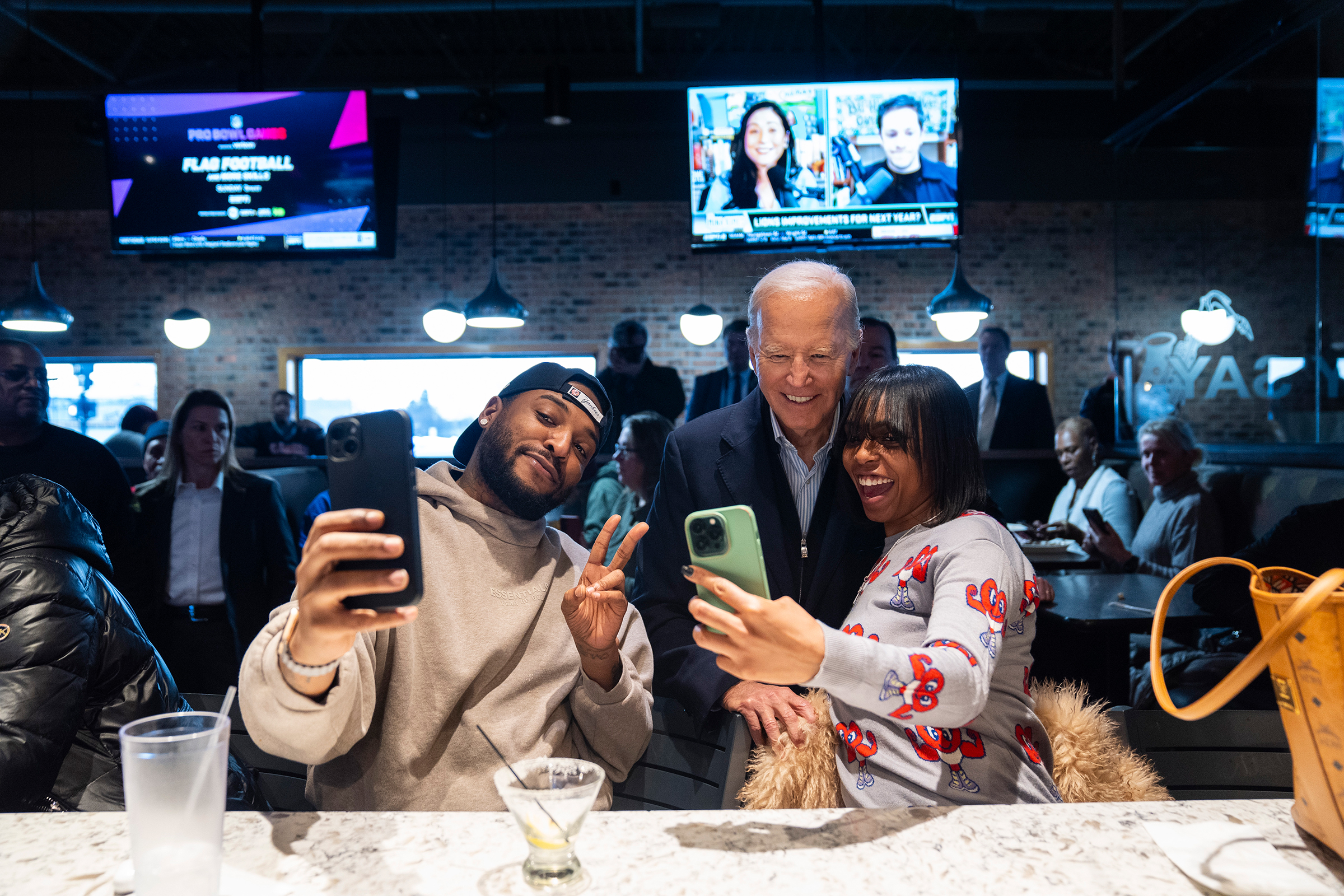 President Joe Biden, center, takes photos with patrons at They Say restaurant during a campaign stop on February 1, in Harper Woods, Michigan. 