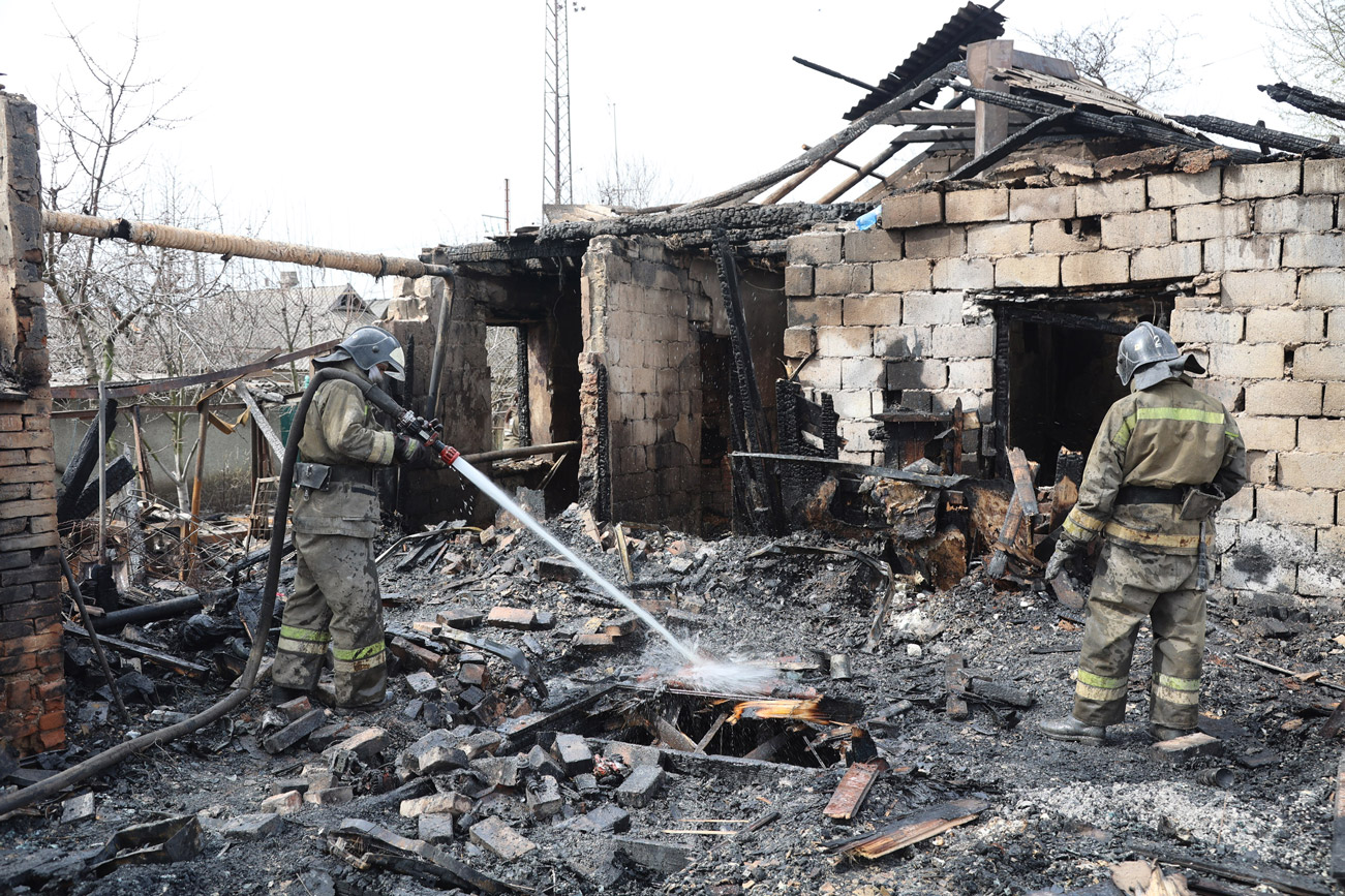 Firefighters put out a fire caused by shelling in a residential area in the village of Yelenovka in Donetsk, on  April 10.