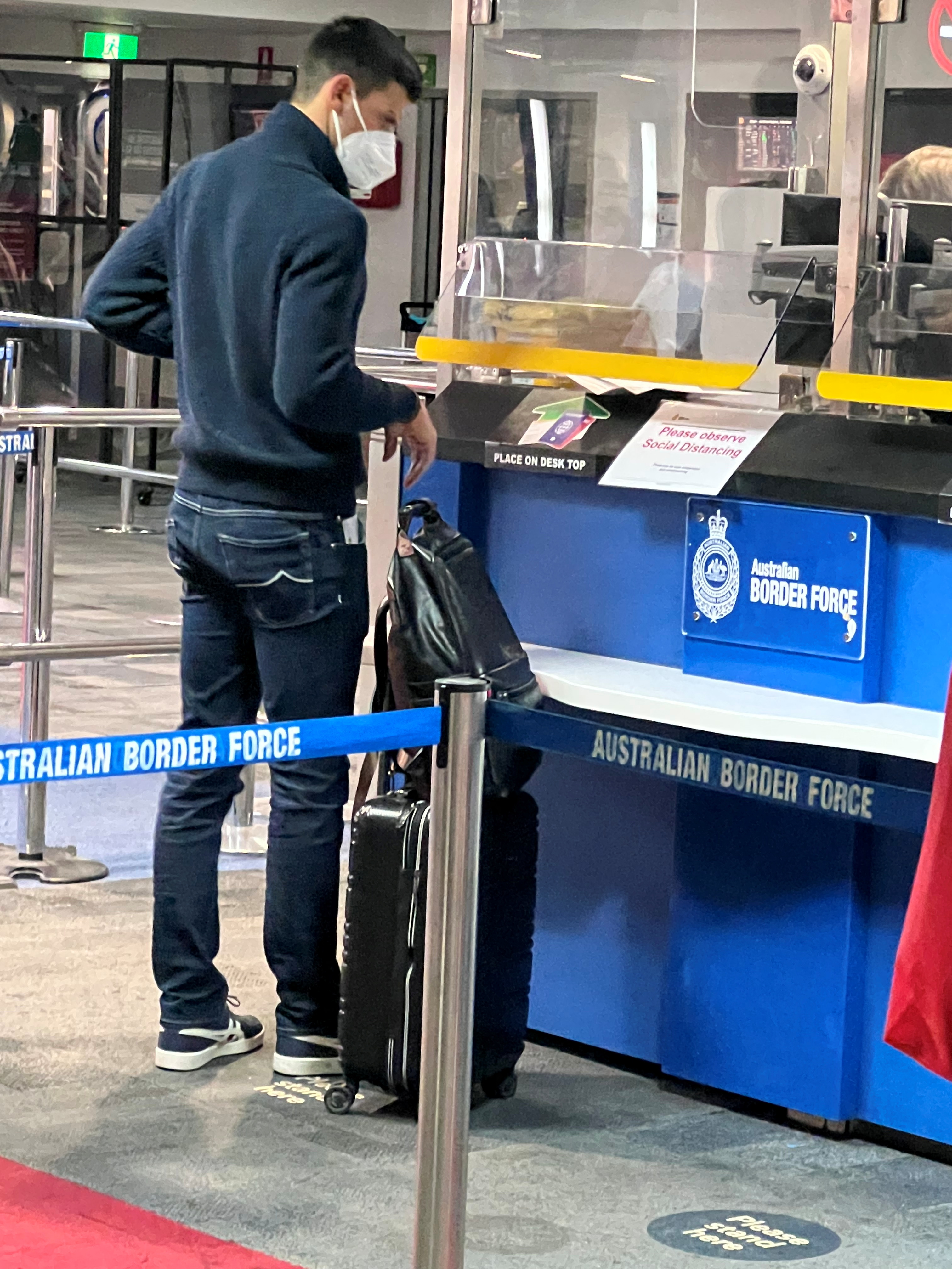 Serbian tennis player Novak Djokovic stands at an Australian Border Force booth at the airport in Melbourne on January 5, 2022. 