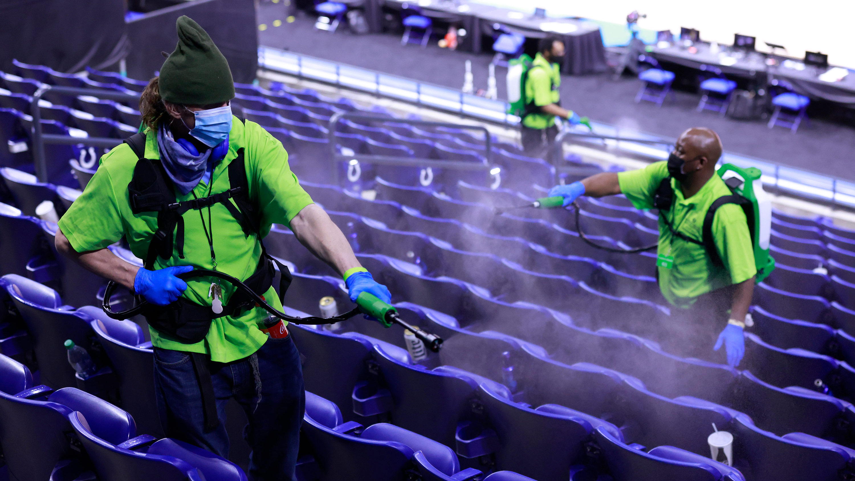 Employees disinfect seats ahead of a Purdue Boilermakers and Ohio State Buckeyes basketball game at Lucas Oil Stadium in Indianapolis, Indiana, on March 12. 