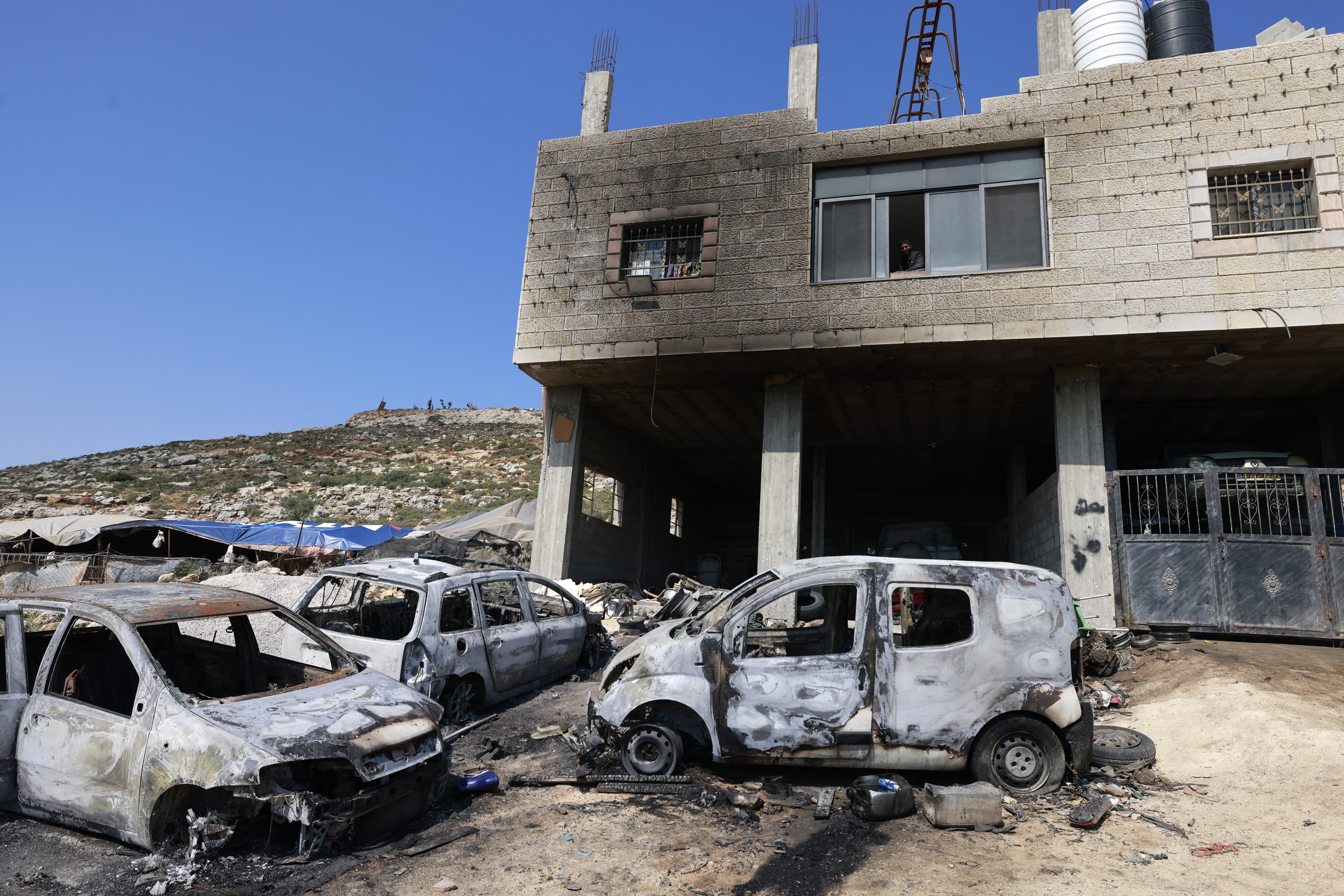Burned cars are seen in the Palestinian village of Al-Mughayyir in the occupied West Bank, on April 13. 