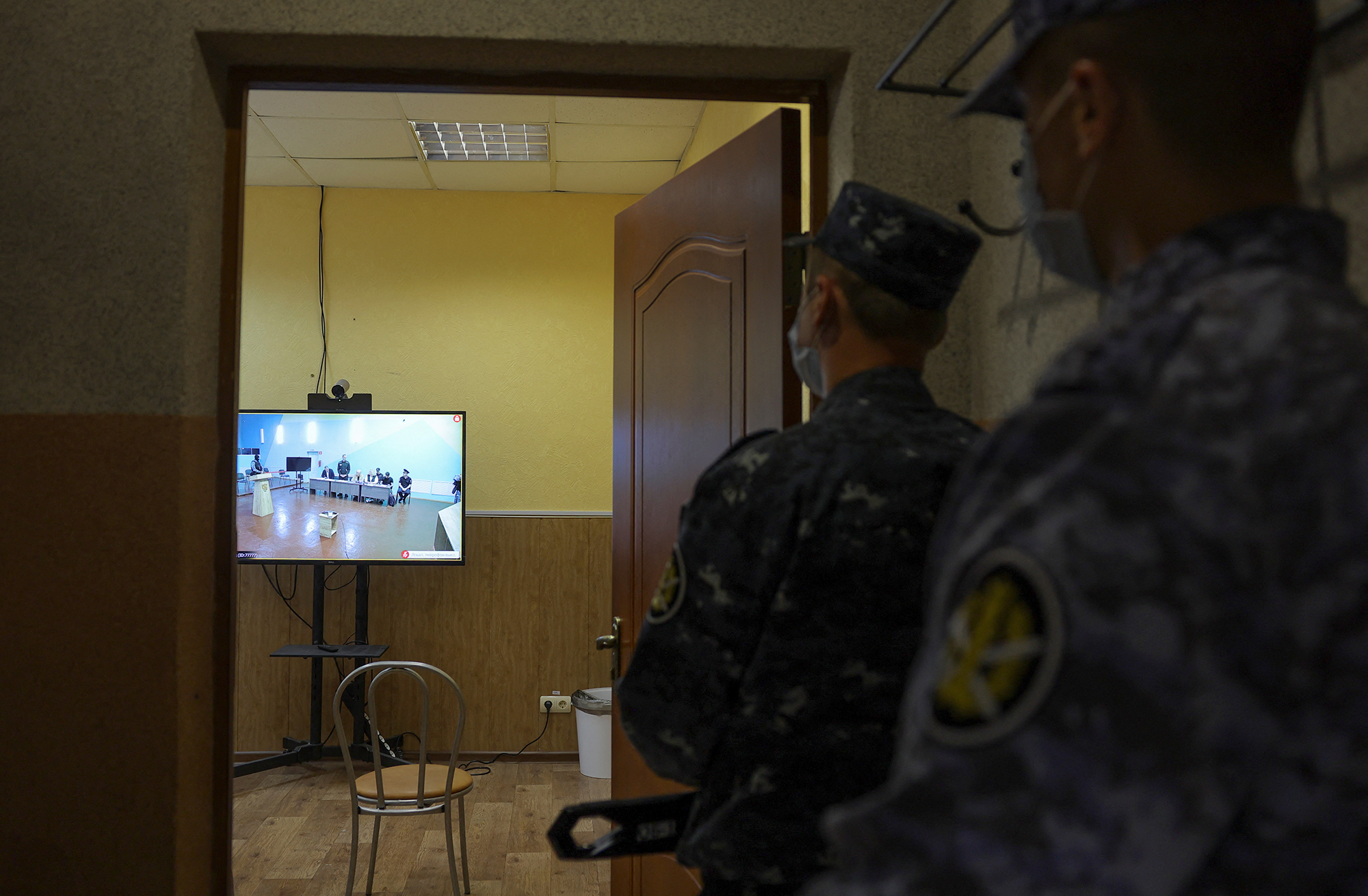 Law enforcement officers look at a screen during a video link to an external hearing of the Moscow City Court in a new criminal case against Russian opposition politician Alexey Navalny, at IK-6 penal colony in the Vladimir region, Russia, on June 19.