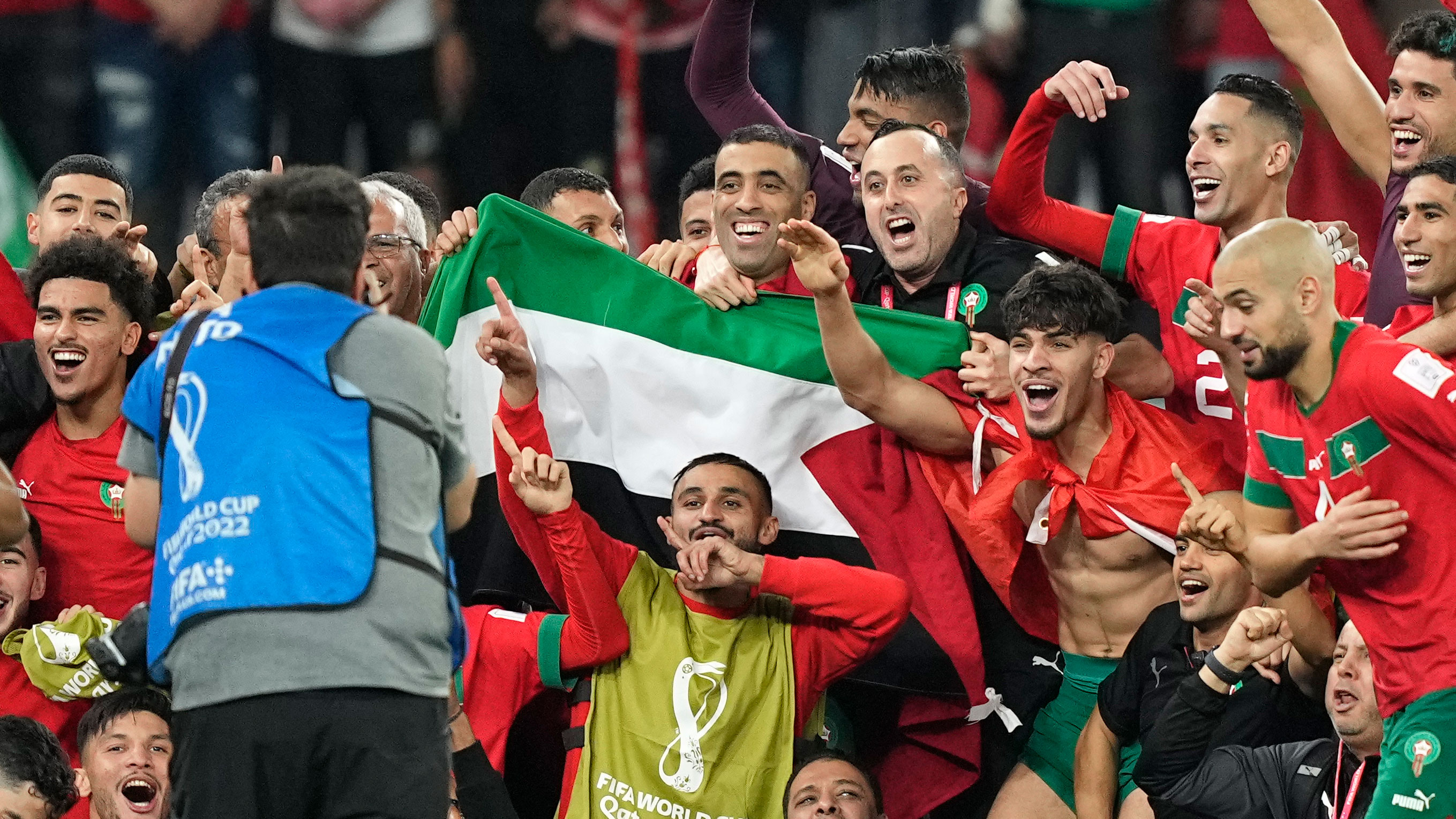 Morocco's team takes a group photo on the pitch holding the Palestinian flag after defeating Spain on December 6.