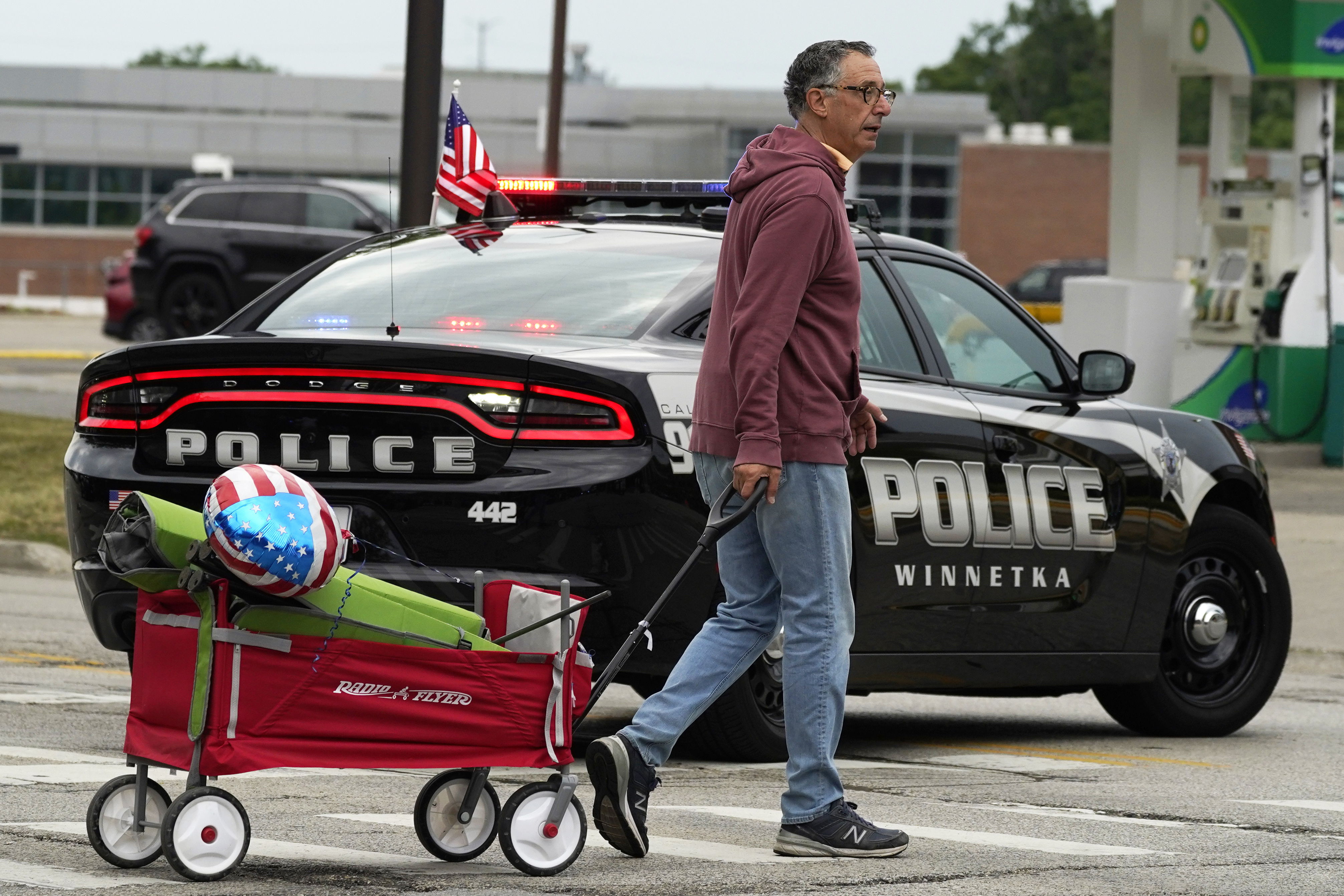 A man carries his belongings after a mass shooting at the Highland Park Fourth of July parade in downtown Highland Park, Illinois, on Monday.