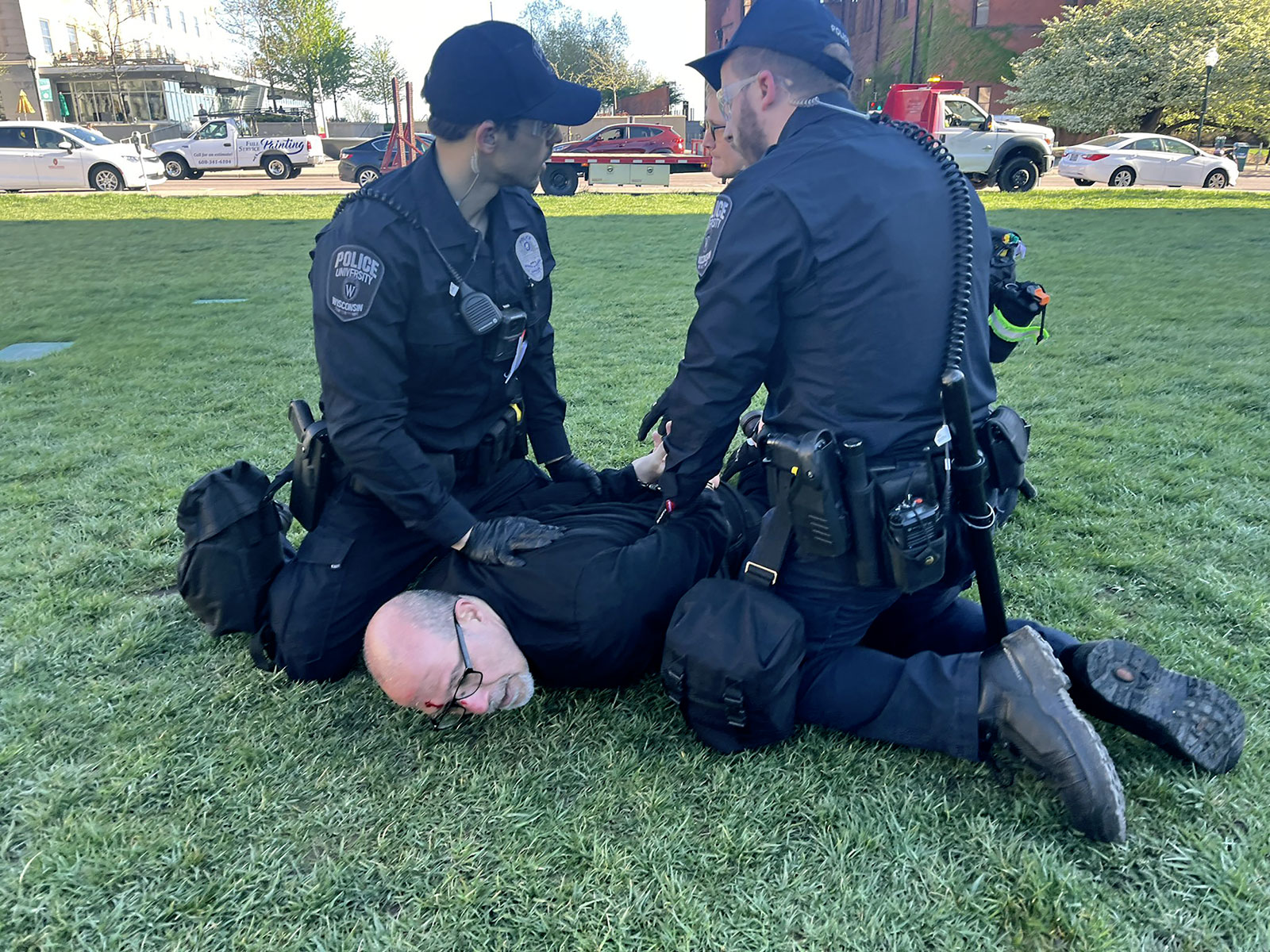 Associate Professor of Community & Environmental Sociology Samer Alatout is seen being held to the ground by University of Wisconsin-Madison Police officers on Wednesday, May 1.