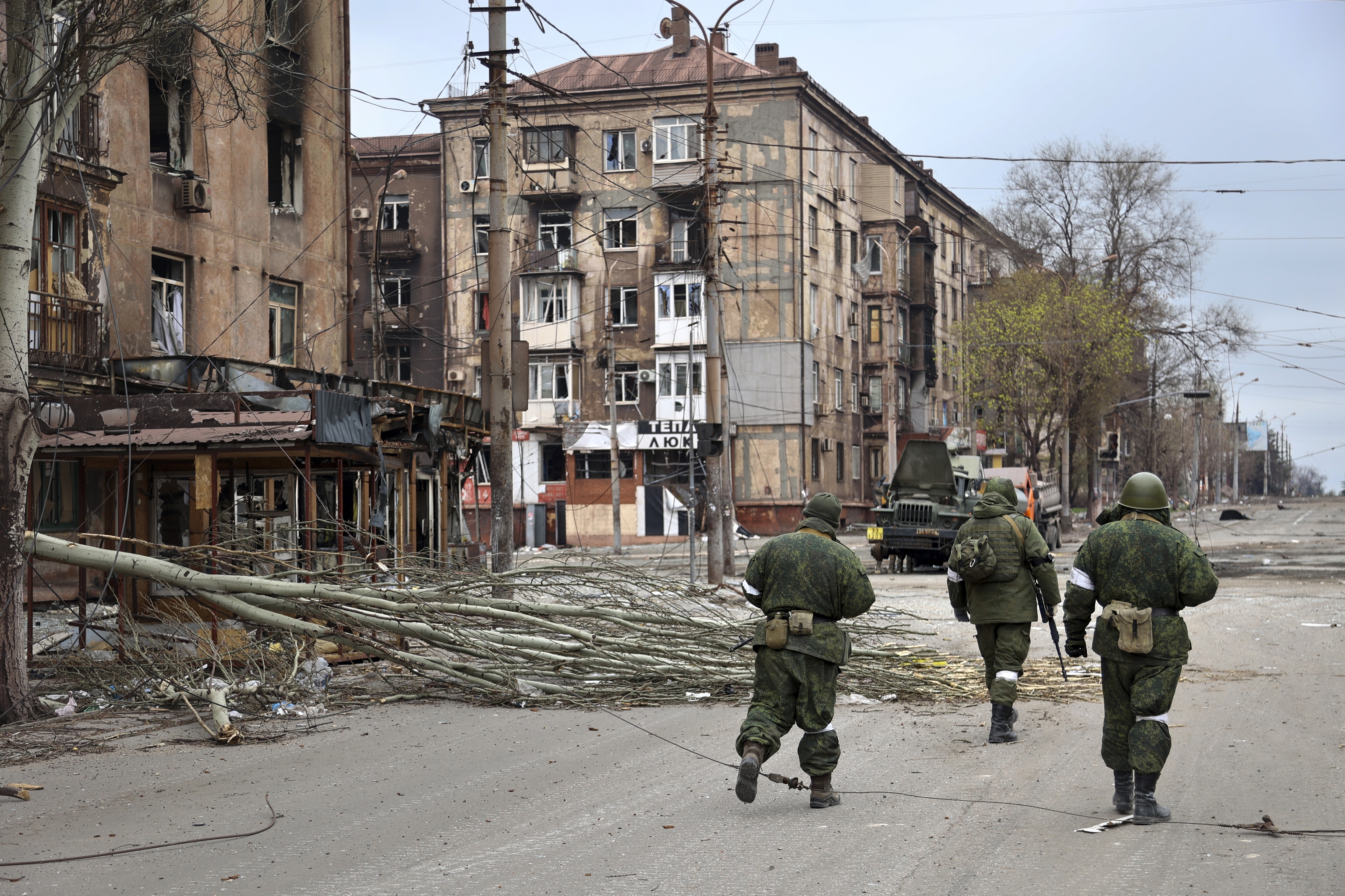 Members of the Donetsk People's Republic militia walk past damaged apartment buildings near the Illich Iron & Steel Works Metallurgical Plant in Mariupol, Ukraine, on April 16.