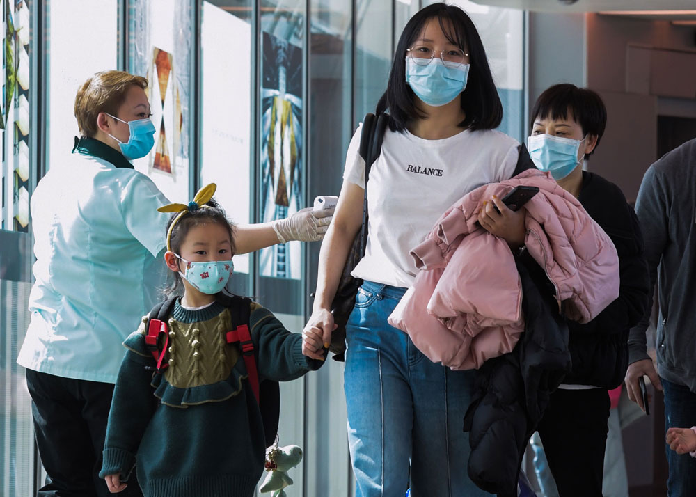 A health officer screens arriving passengers from China at Changi International airport in Singapore.