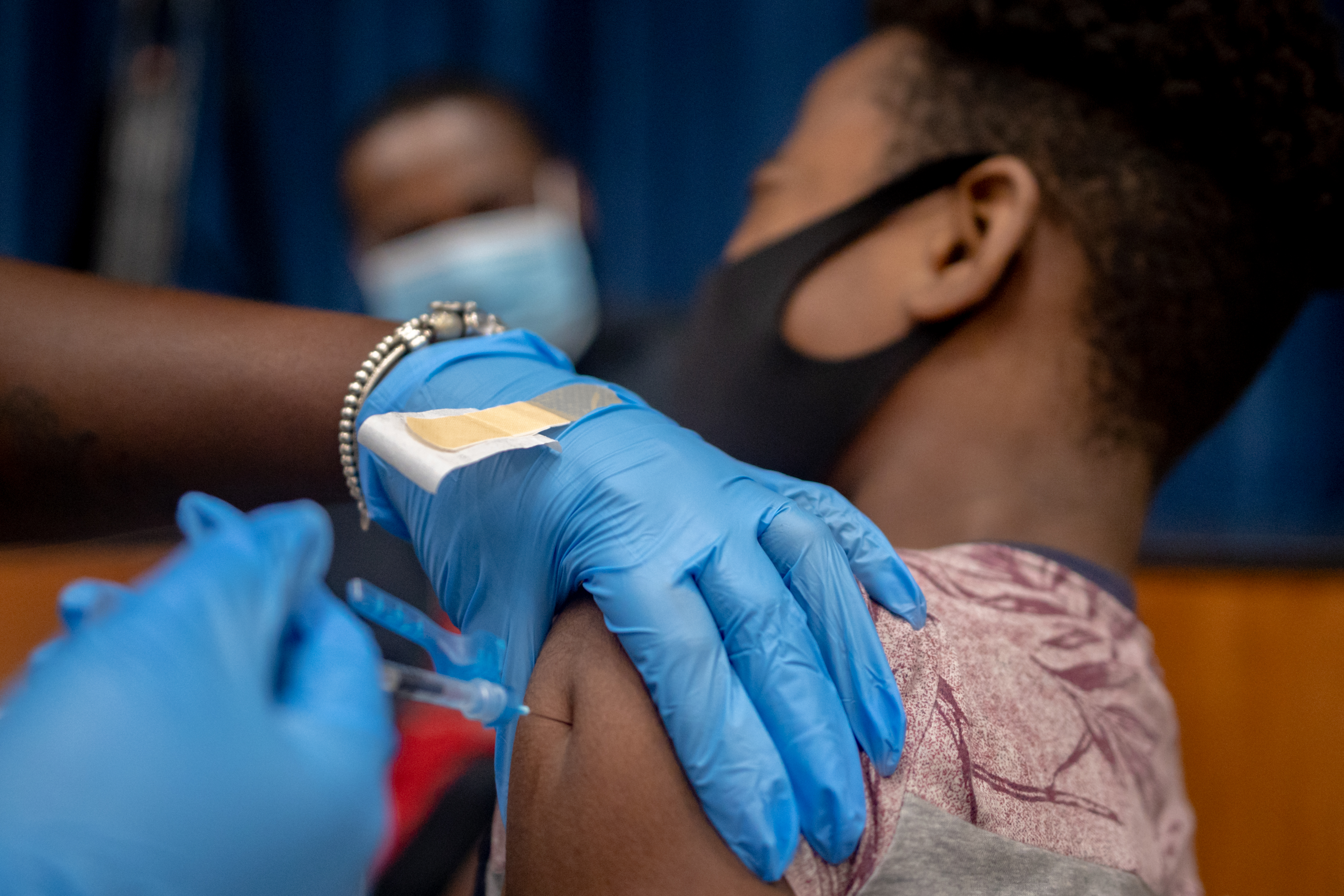 A healthcare worker administers a dose of the Pfizer-BioNTech Covid-19 vaccine to a teenager at West Philadelphia High School in Philadelphia, Pennsylvania, U.S., on Tuesday, August 4, 2021. 