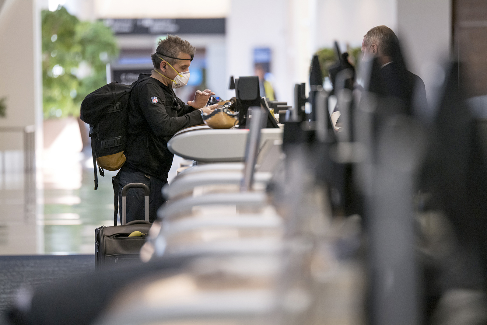 A traveler wearing a protective mask and gloves checks in at the Delta Air Lines Inc., counter at San Francisco International Airport in California on April 2.