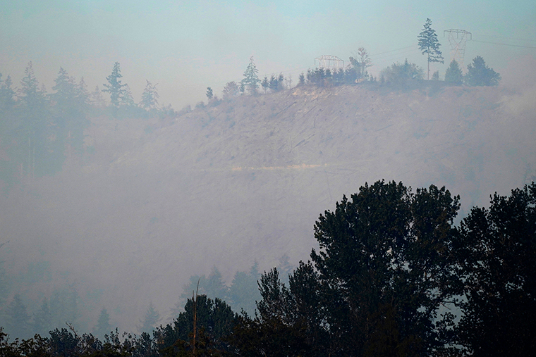 Smoke rises from a hillside burned by a wildfire, Tuesday, September 8, near Sumner, Washington.