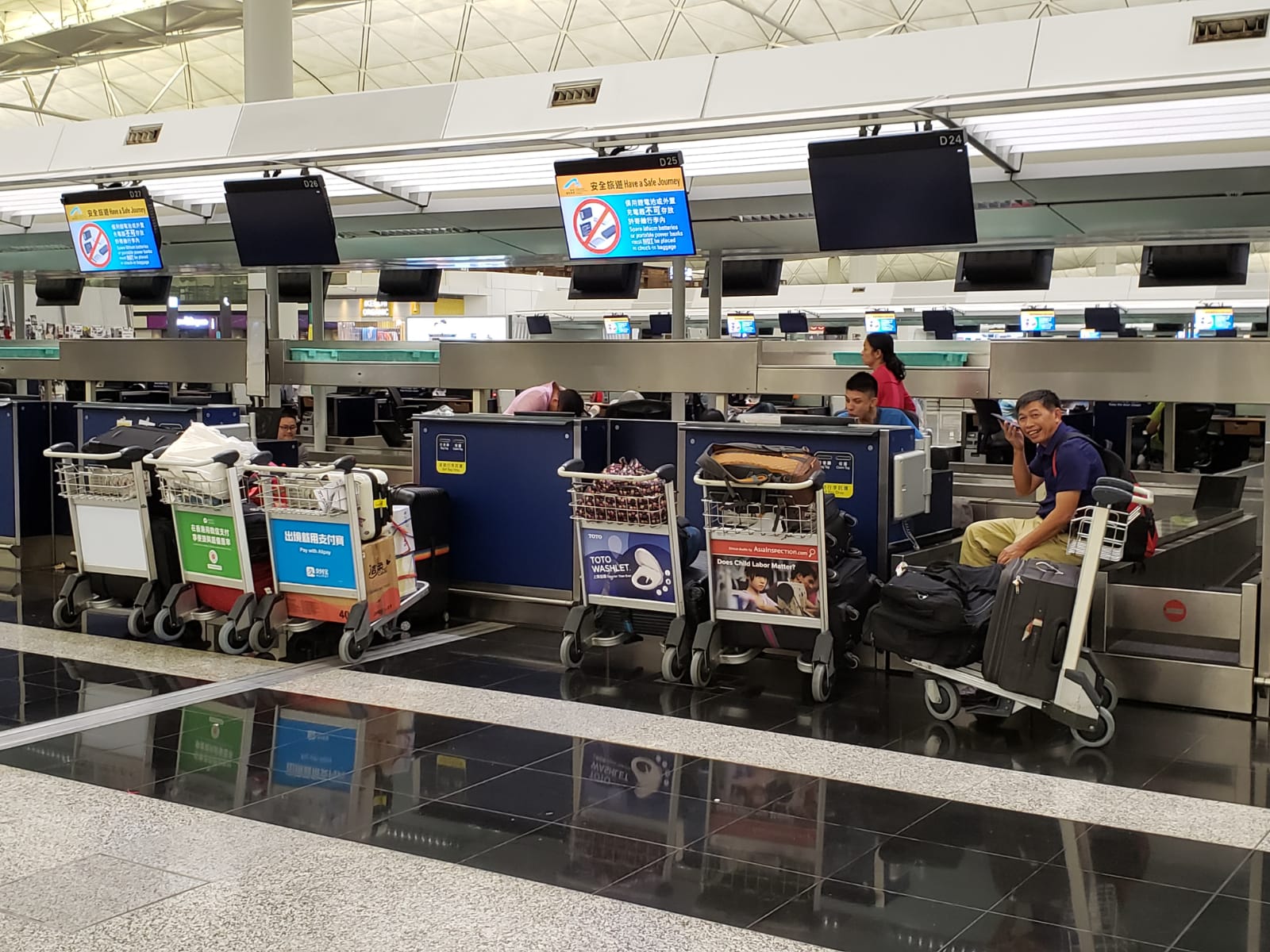 Protesters and travelers sit behind check-in counters at Hong Kong airport, where there no staff are in sight.