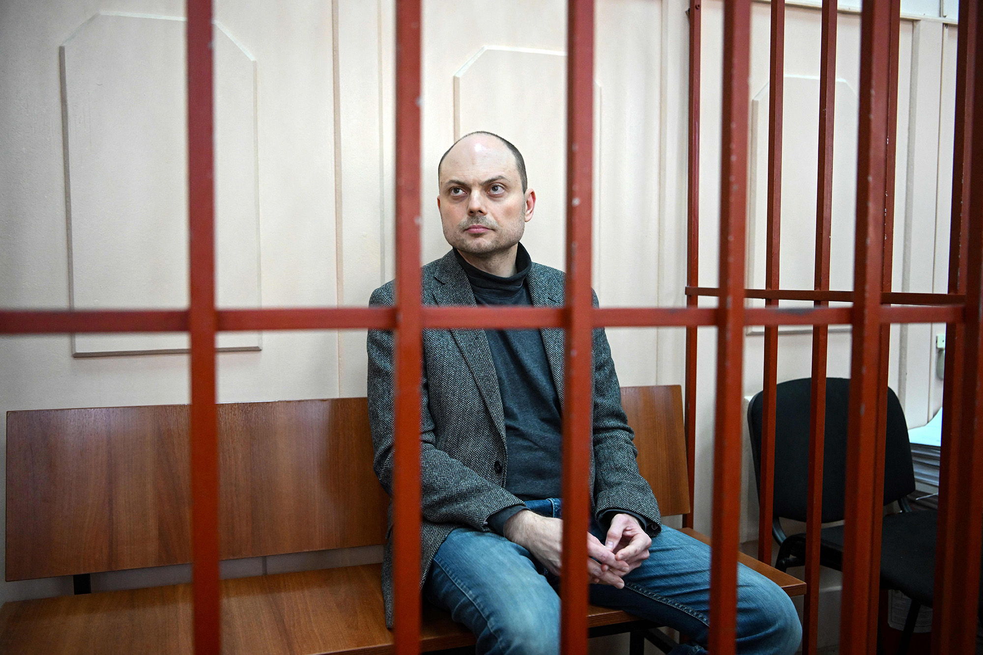 Russian opposition activist Vladimir Kara-Murza sits on a bench inside a defendants' cage during a hearing at the Basmanny court in Moscow, Russia, on October 10.