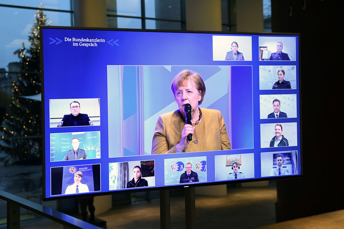 German Chancellor Angela Merkel is seen on a screen as she attends a virtual meeting with police officers at the Chancellery in Berlin on Nov. 30.