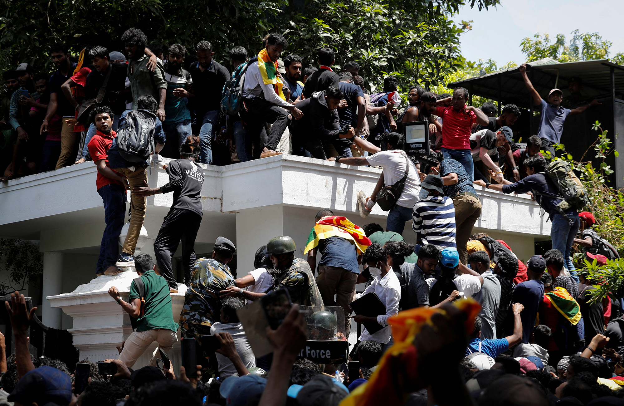 Protesters climb the front gate of Sri Lanka's Prime Minister Ranil Wickremesinghe's office during a protest in Colombo, Sri Lanka, on July 13.