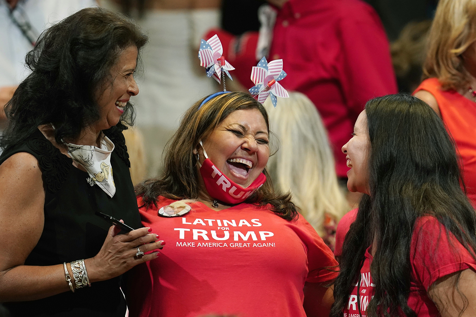 Supporters of President Donald Trump share a laugh as they wait for the president to participate in a Latinos for Trump Coalition roundtable on Monday, September 14 in Phoenix. 