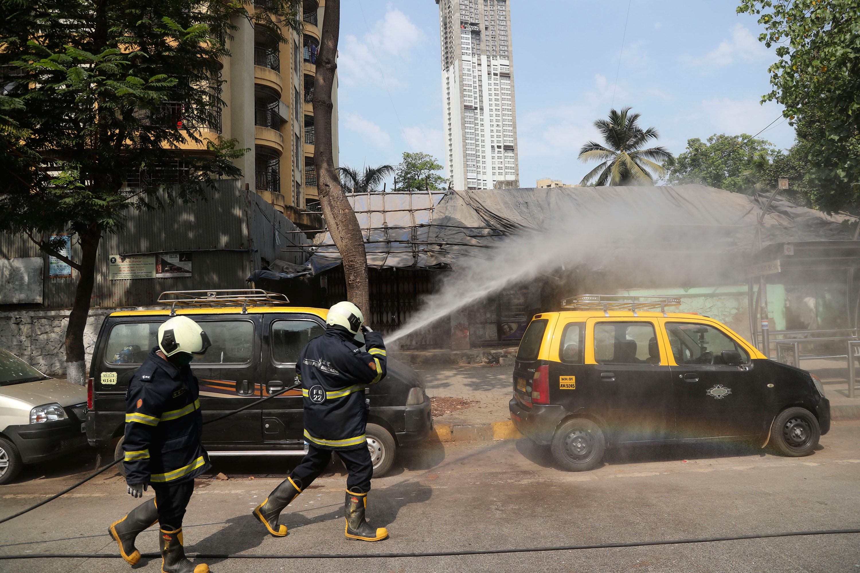 Members of the fire brigade spray disinfectant in the streets of Mumbai, India on March 30.