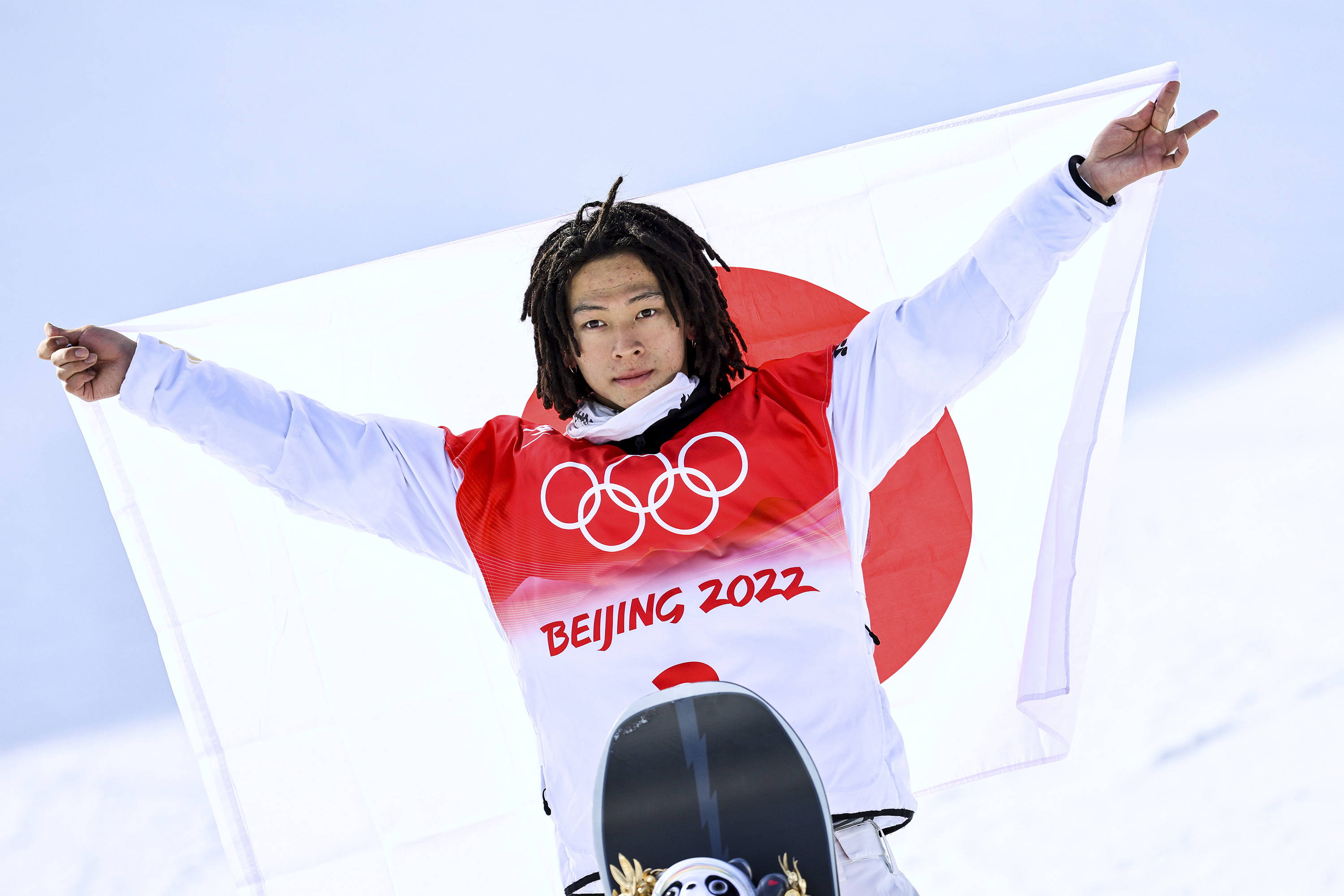 Snowboarder Ayumu Hirano poses with the flag of Japan after claiming gold on Friday.