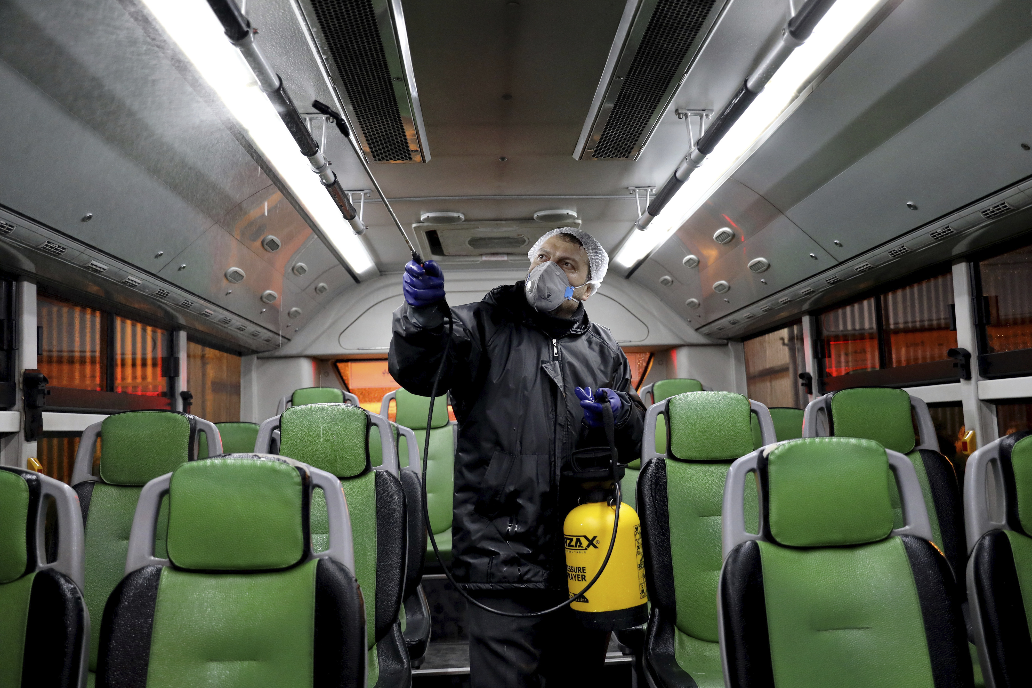 A worker disinfects a public bus against coronavirus in Tehran, Iran, early on Wednesday, February 26.