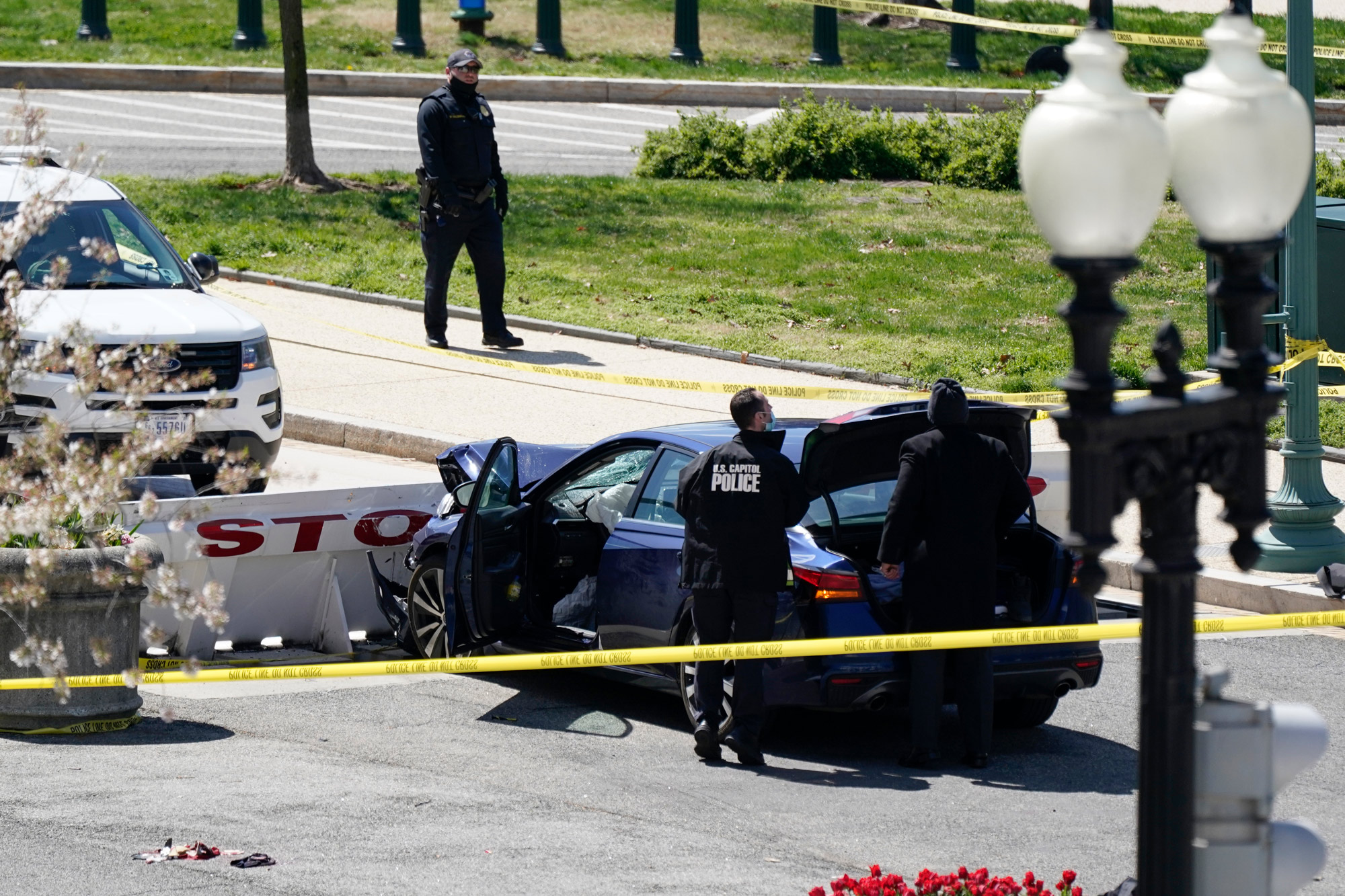 U.S. Capitol Police officers stand near a car that crashed into a barrier on Capitol Hill in Washington, DC, on April 2.