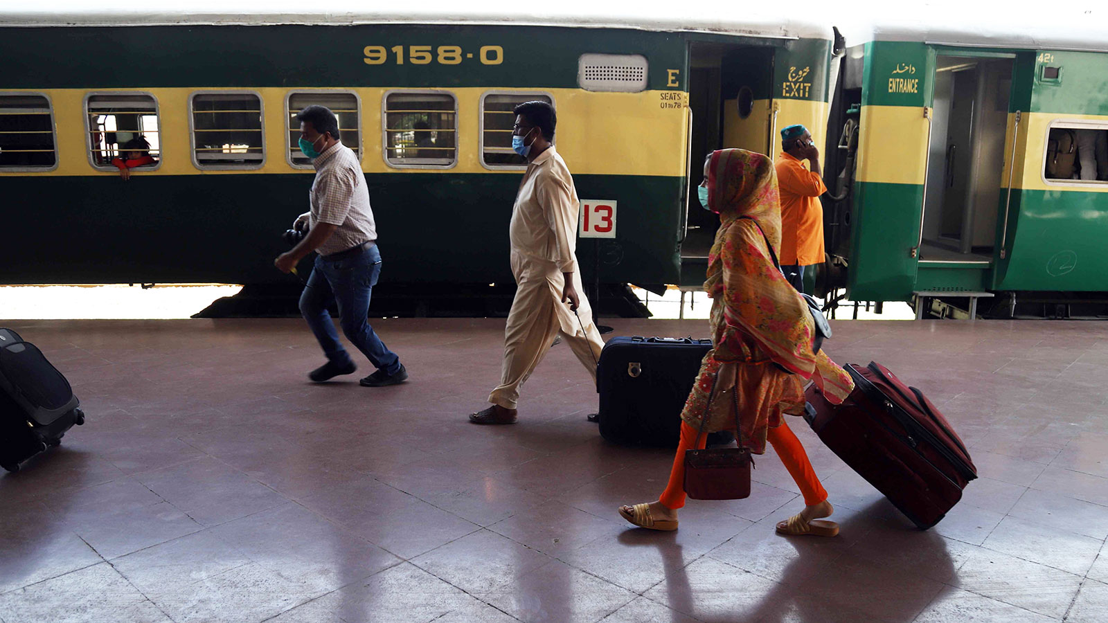 Passengers wearing face masks as a precaution against coronavirus arrive at Rawalpindi railway station in Pakistan on Wednesday.