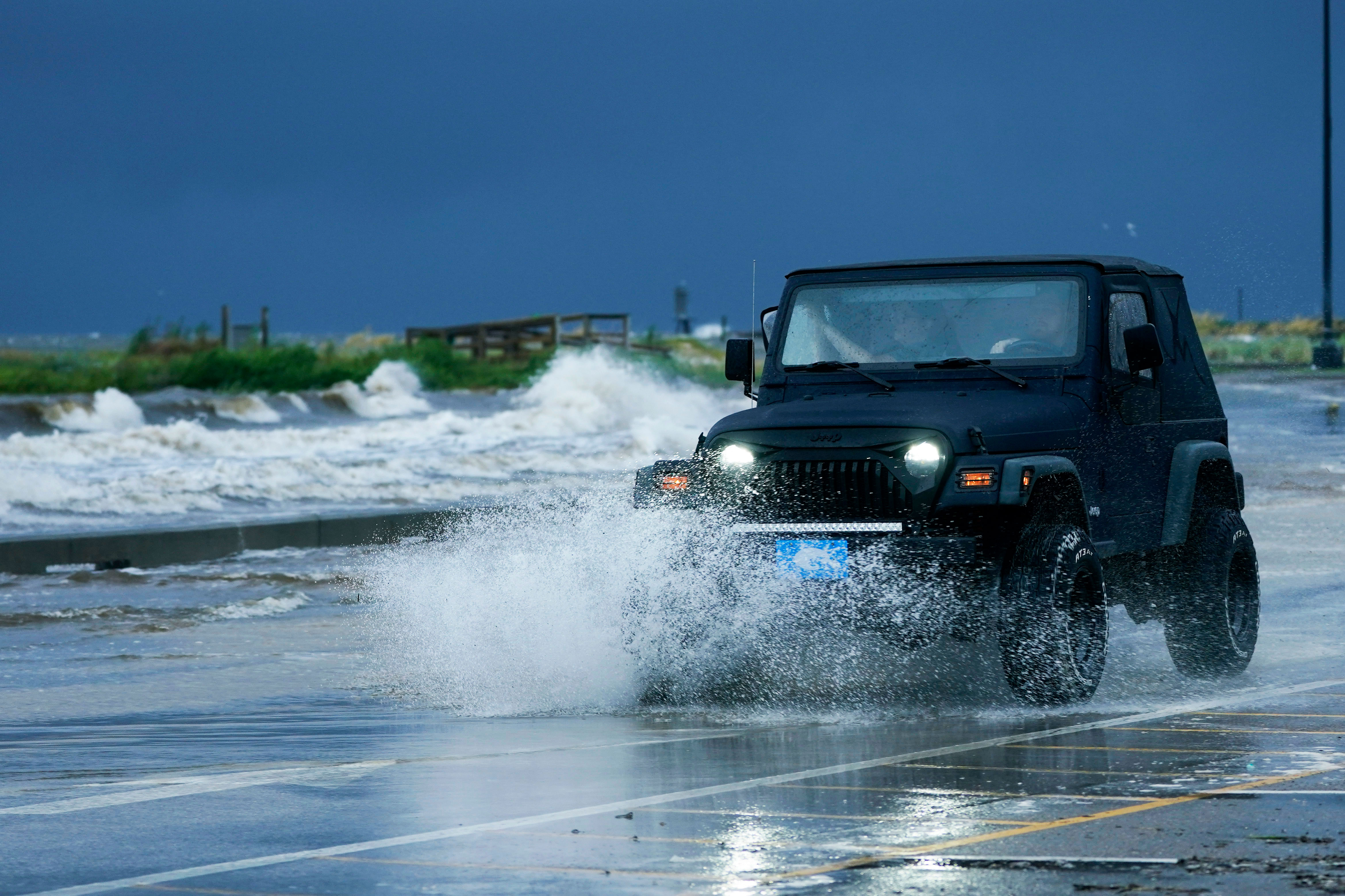 People drive through floodwaters in Gulfport, Mississippi, on August 29, 2021.