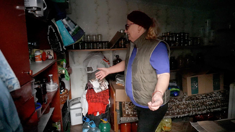Olga Gritsuniak shows the stores of food in her basement, where she and her husband often took shelter while the Russians occupied the area.