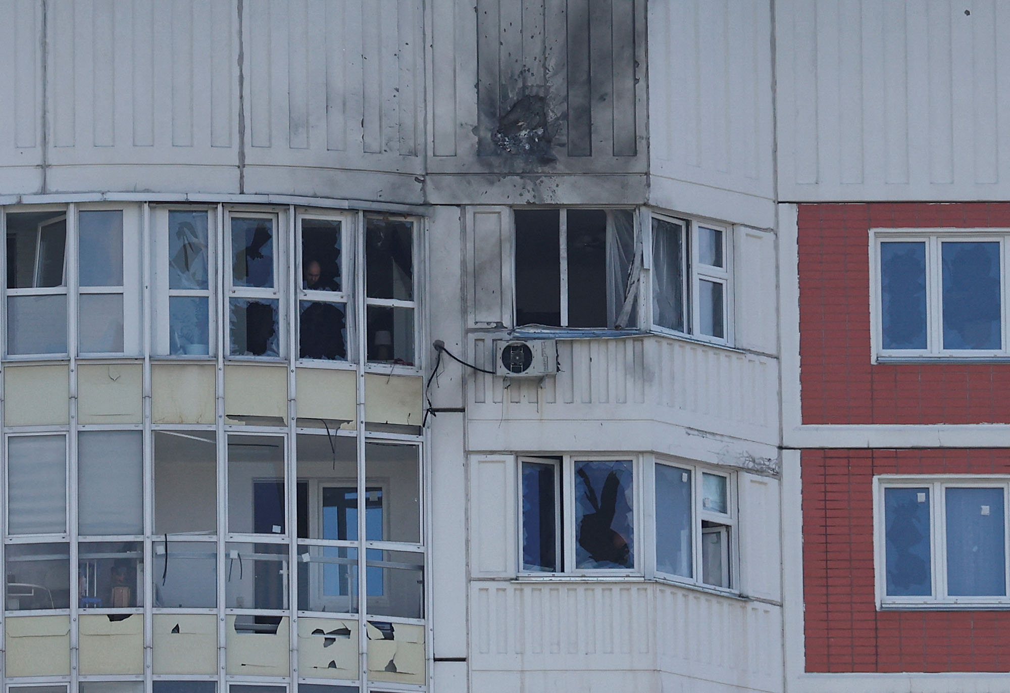 A man is seen through a window of a damaged multi-storey apartment block following a reported drone attack in Moscow, Russia, on May 30.