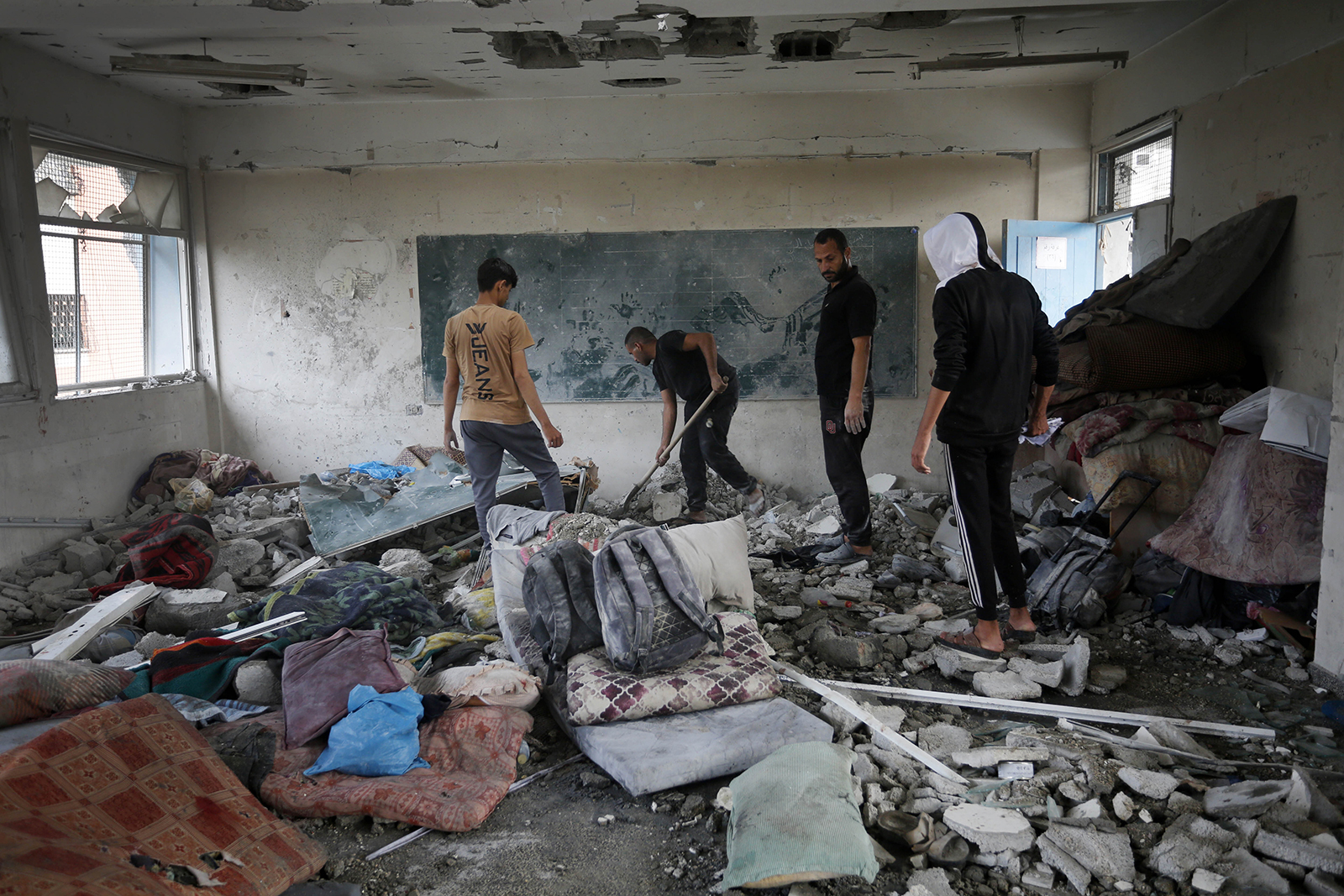 Palestinians inspect a damaged school following an Israeli airstrike in Nuseirat refugee camp in Gaza, on June 06.