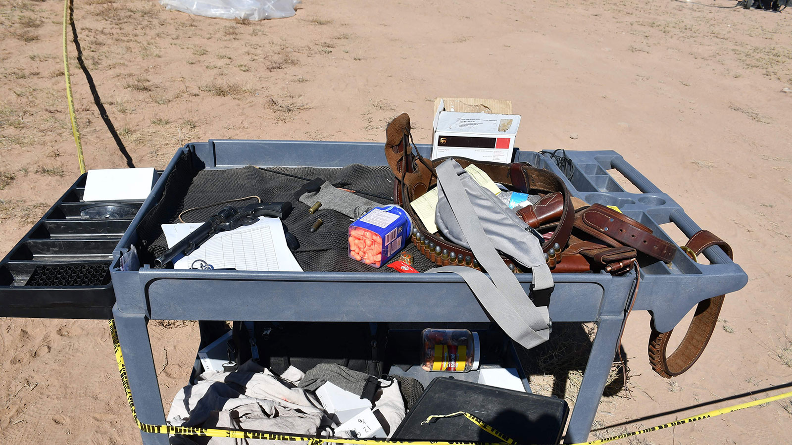 A gun and ammunition are seen in a prop cart near the shooting scene.