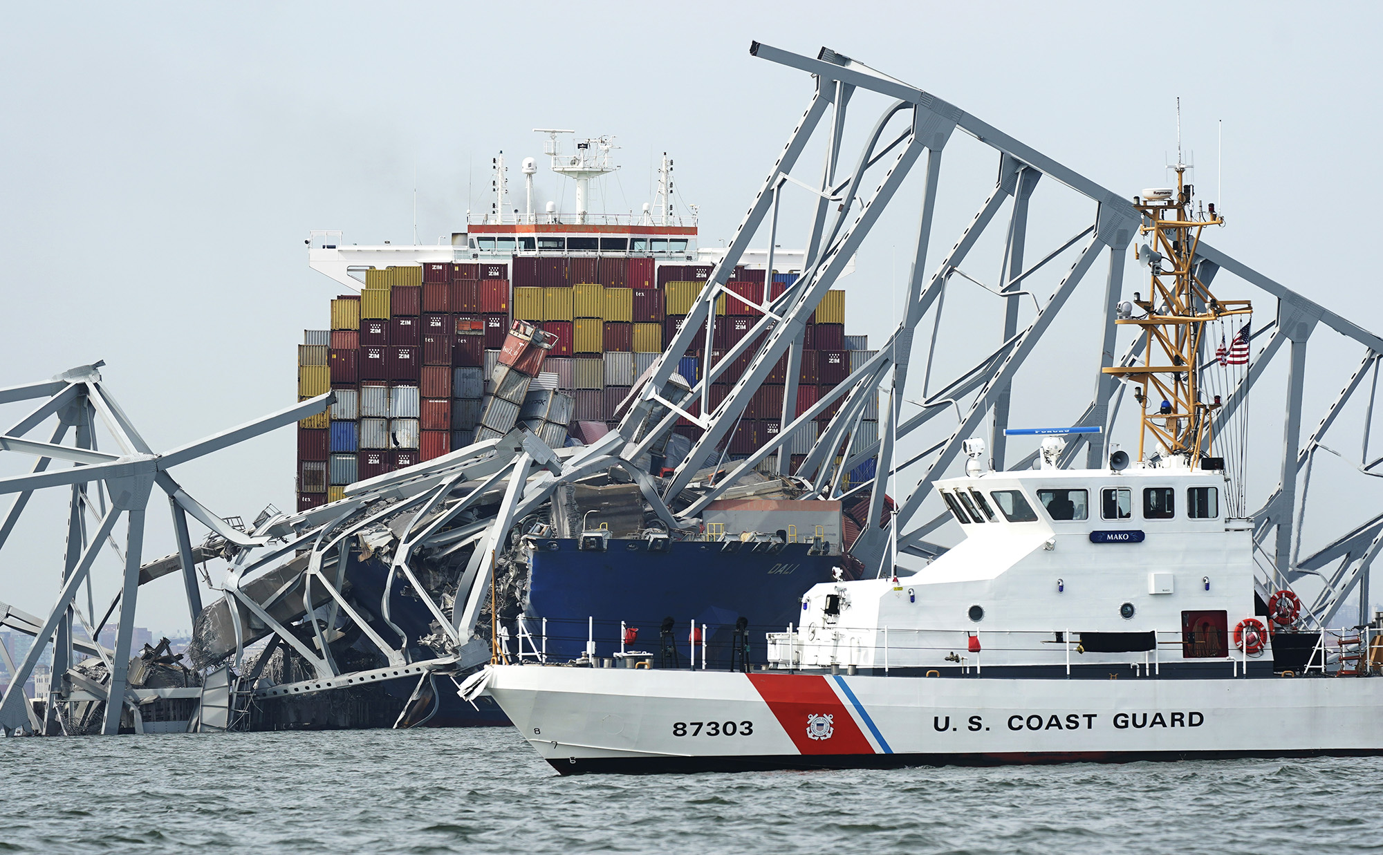 A Coast Guard cutter passes part of the structure of the Francis Scott Key Bridge on March 26, in Baltimore.