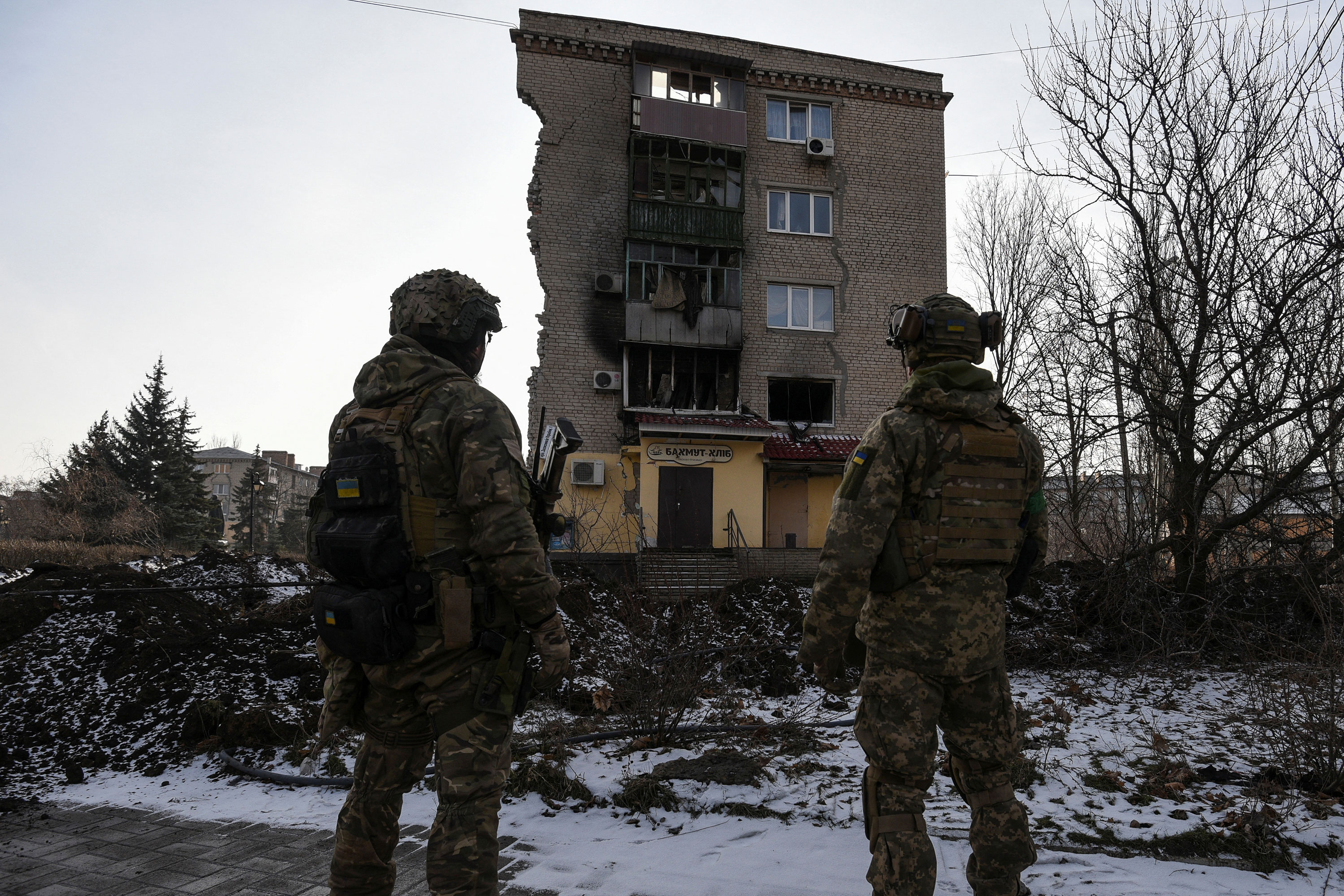 Ukrainian servicemen stand next to a residential building heavily damaged during a Russian military strike in Bakhmut on Tuesday. 