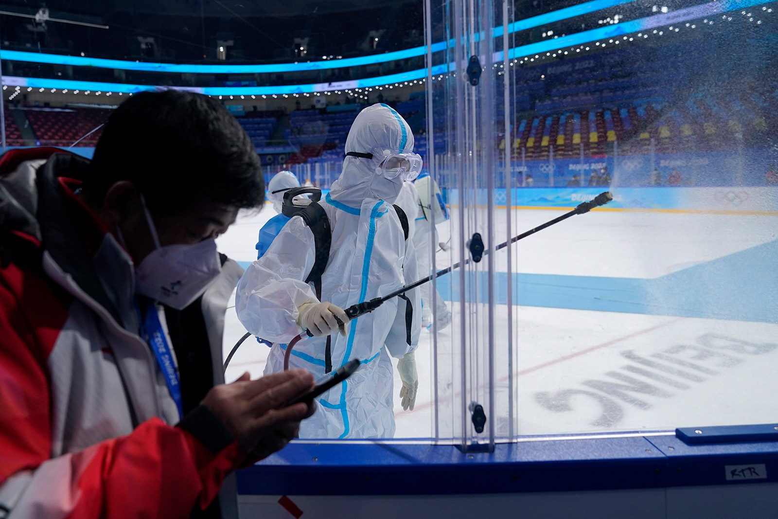 A worker disinfects the ice rink after the women's gold-medal hockey game on Thursday.