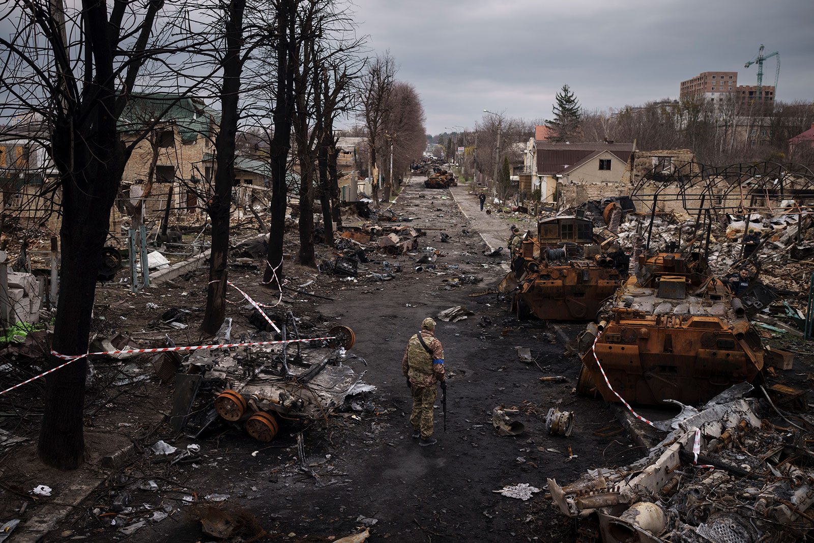 A Ukrainian serviceman walks amid destroyed Russian tanks in Bucha on Wednesday, April 6.