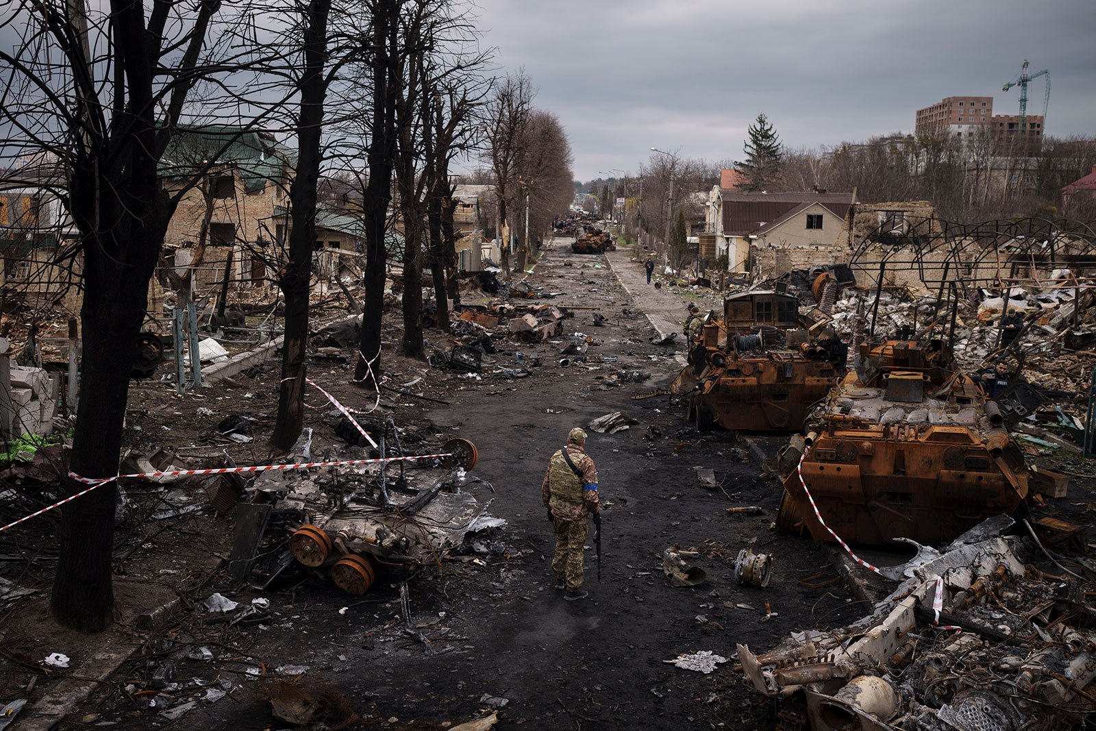 Un militaire ukrainien marche au milieu de chars russes détruits à Bucha le mercredi 6 avril.