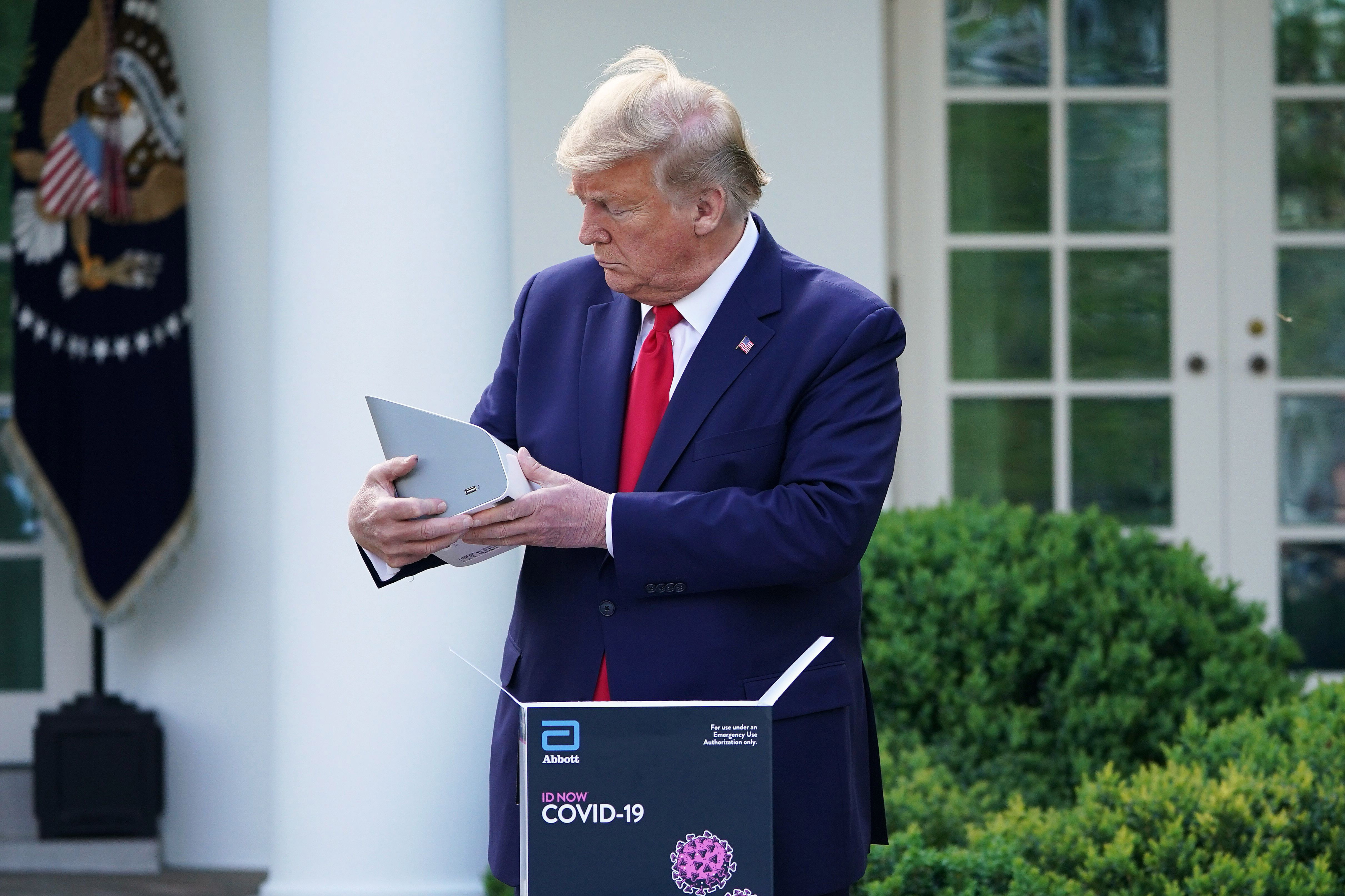 President Donald Trump holds a 5-minute test for Covid-19 from Abbott Laboratories during a briefing on the novel coronavirus at the White House on March 30.