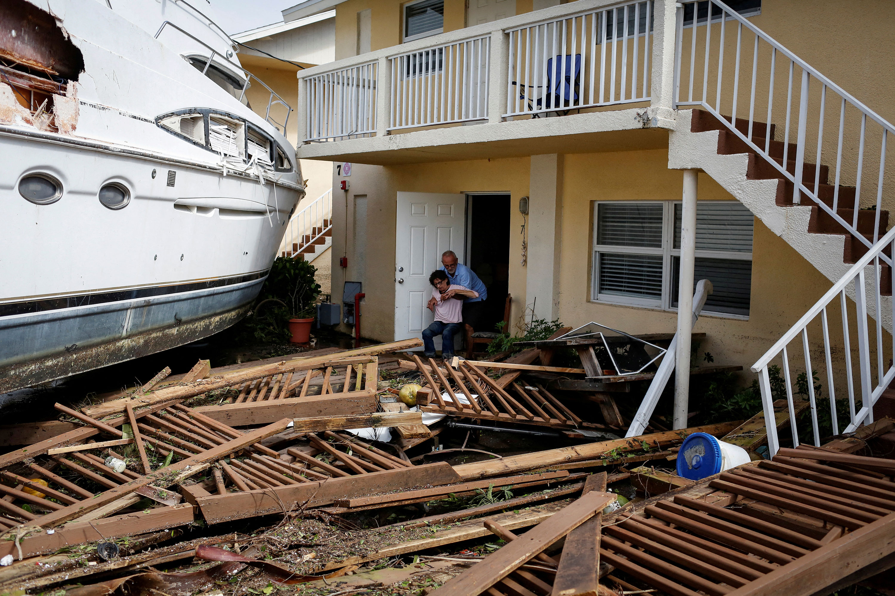 A man helps a woman among debris at a downtown condominium in Fort Myers, Florida, on Thursday.