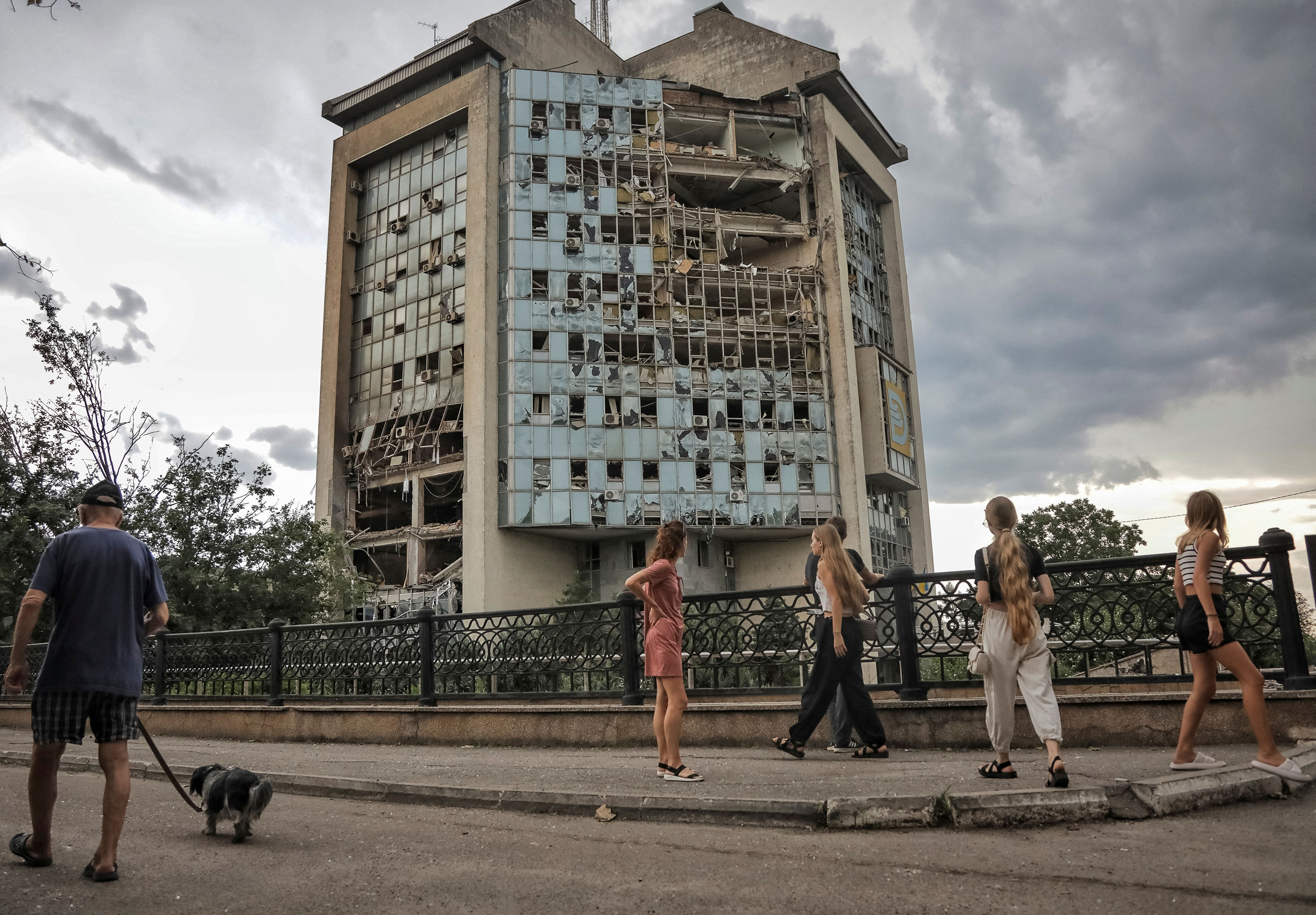 People walk by a Black Sea Danube shipping company building damaged in a Russian drone strike in Izmail, Odesa region, Ukraine, on August 2. 