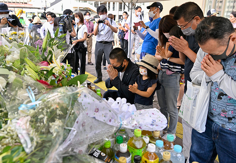 People pray at a makeshift memorial on Saturday near the scene where Shinzo Abe was shot.