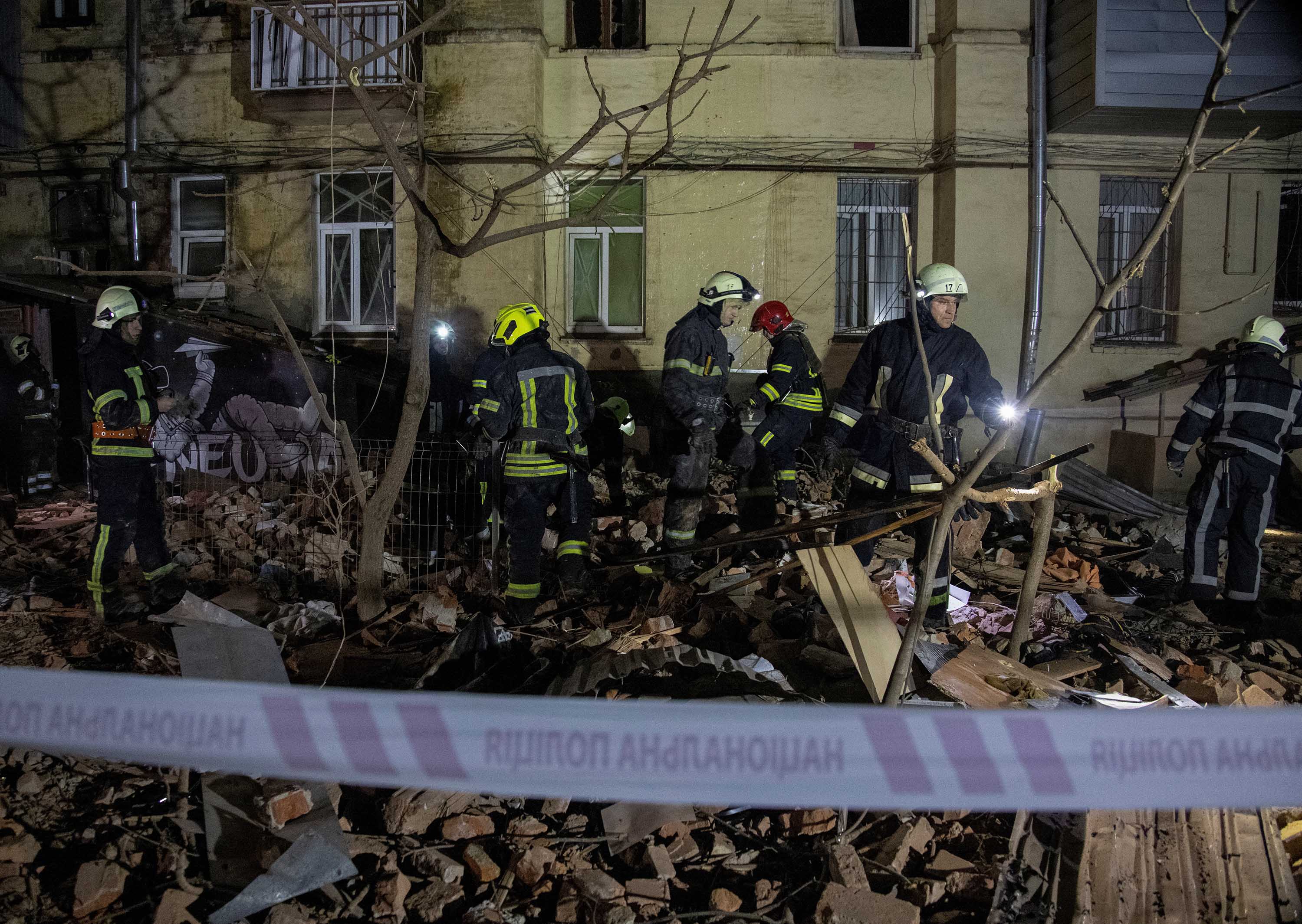 Reddingswerkers zijn aan het werk op de plek waar op 30 januari een flatgebouw zwaar werd beschadigd door een Russische raketaanval in Kharkiv, Oekraïne. 