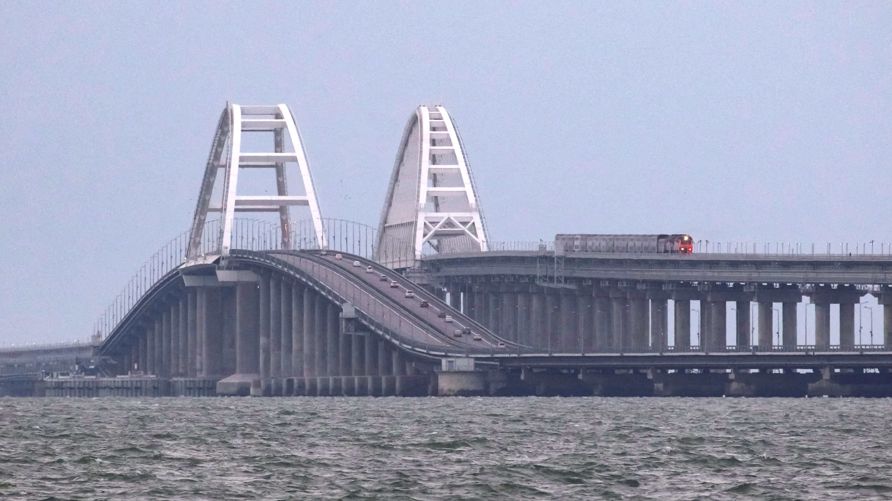 A passenger train and cars travel along on the Kerch bridge in Crimea, on October 9.