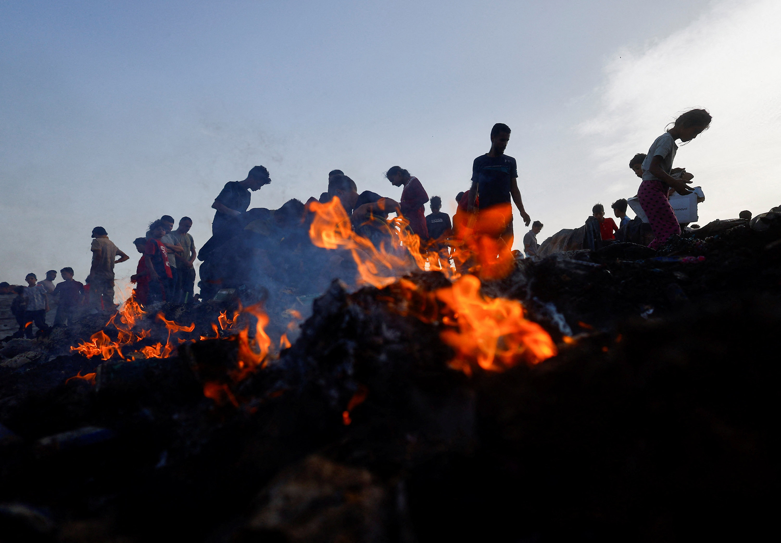 Palestinians search for food among burning debris in the aftermath of an Israeli strike in Rafah, on May 27.