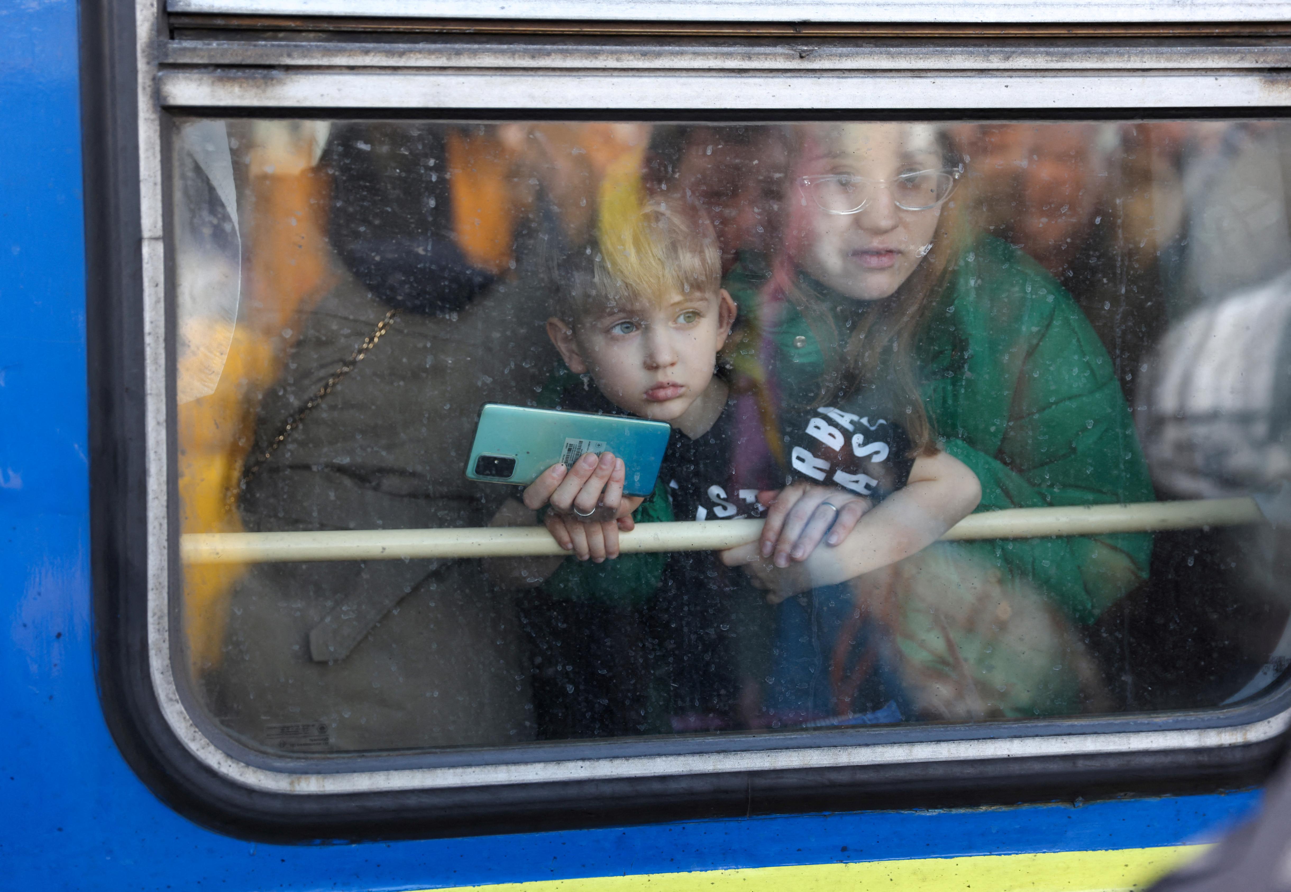 A woman and her son look out from a train leaving Kyiv station en route to the western Ukrainian city of Lviv on February 25.