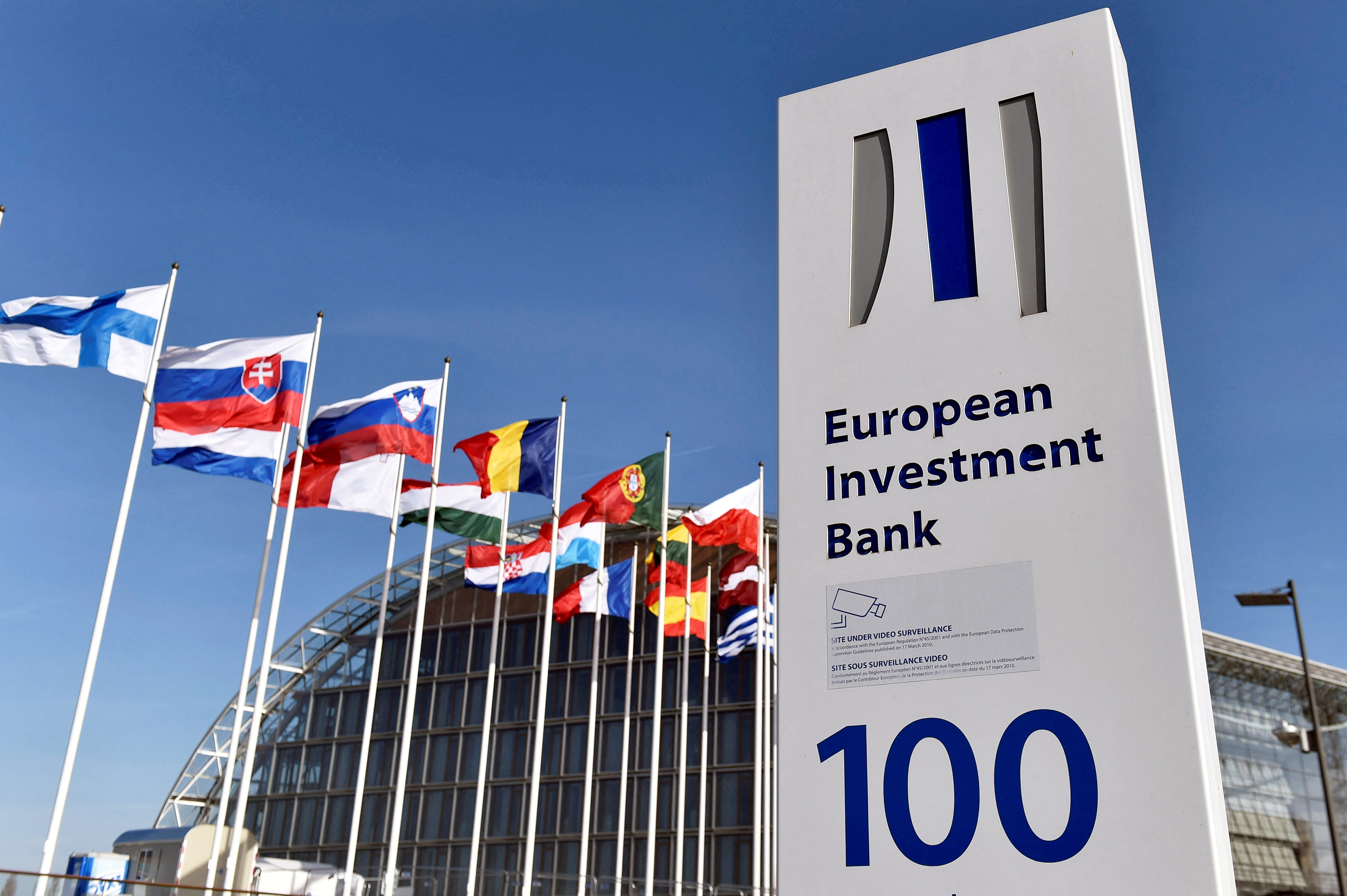 Flags are seen behind the sign of the��European Investment Bank in Luxembourg in 2017.