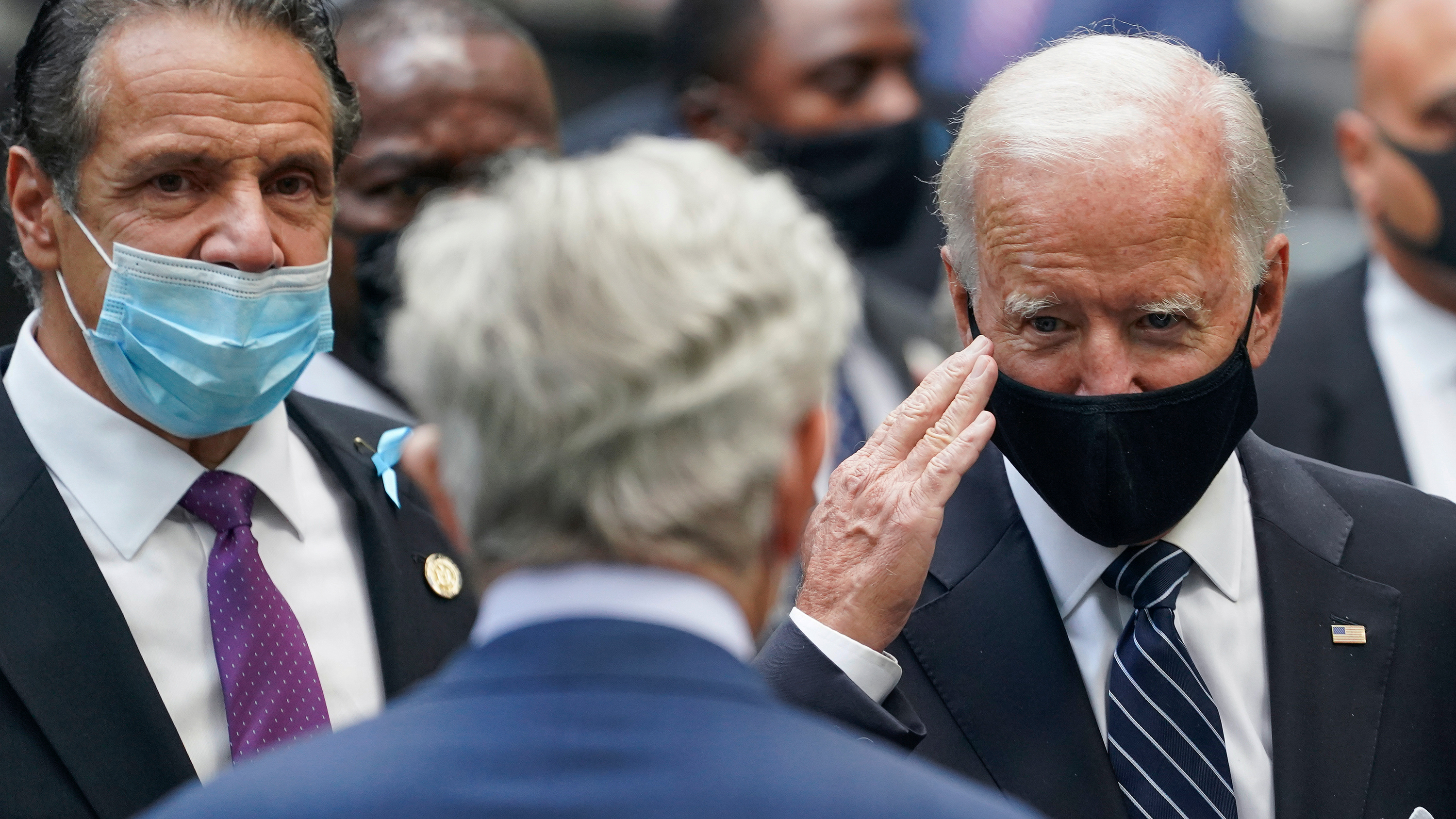 Democratic presidential candidate Joe Biden salutes a guest alongside New York Gov. Andrew Cuomo, left, at the National September 11 Memorial and Museum in New York on September 11.