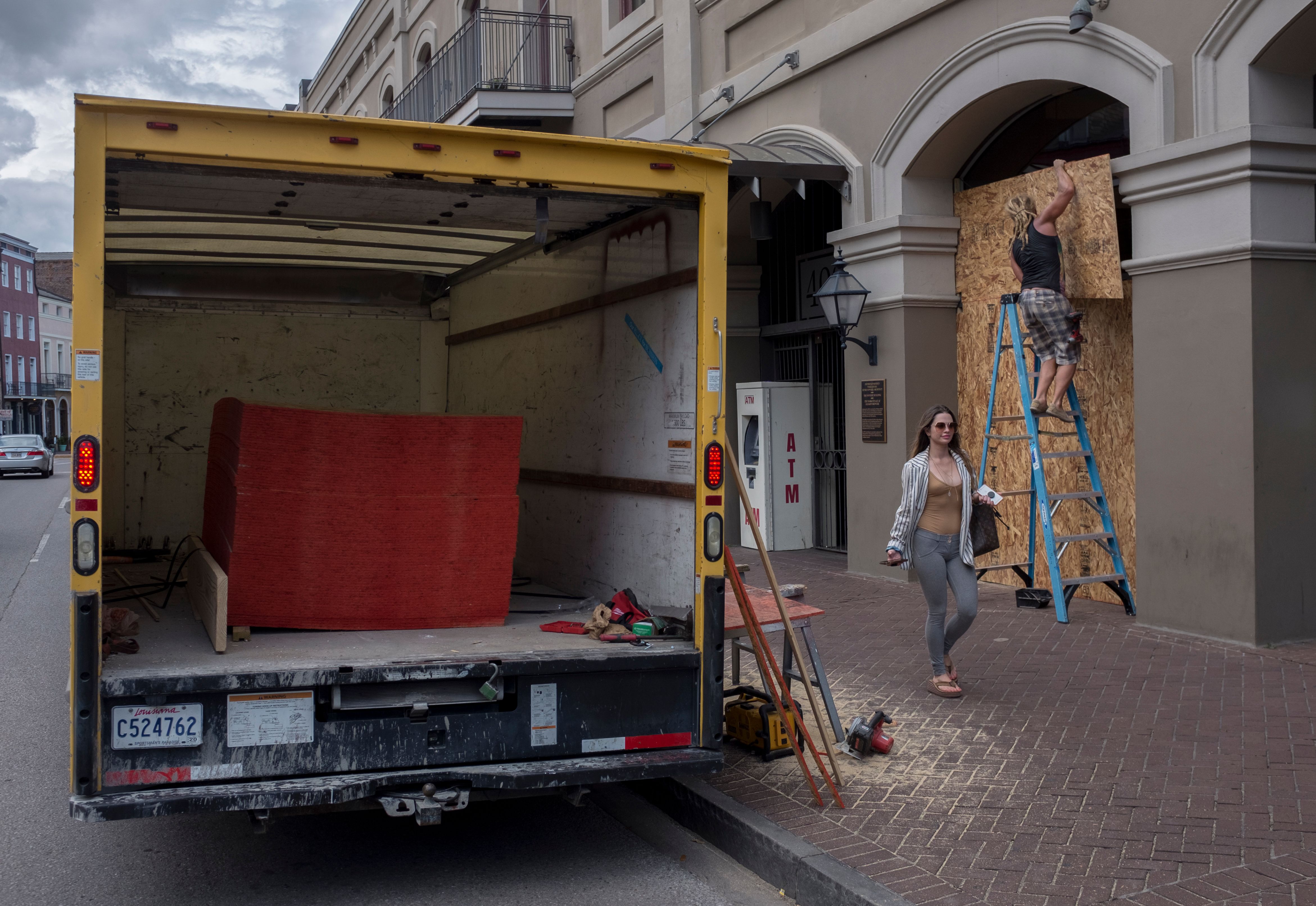 Matt Harrington boards up a Vans shoe and apparel store near the French Quarter in New Orleans as tropical storm Barry approaches.