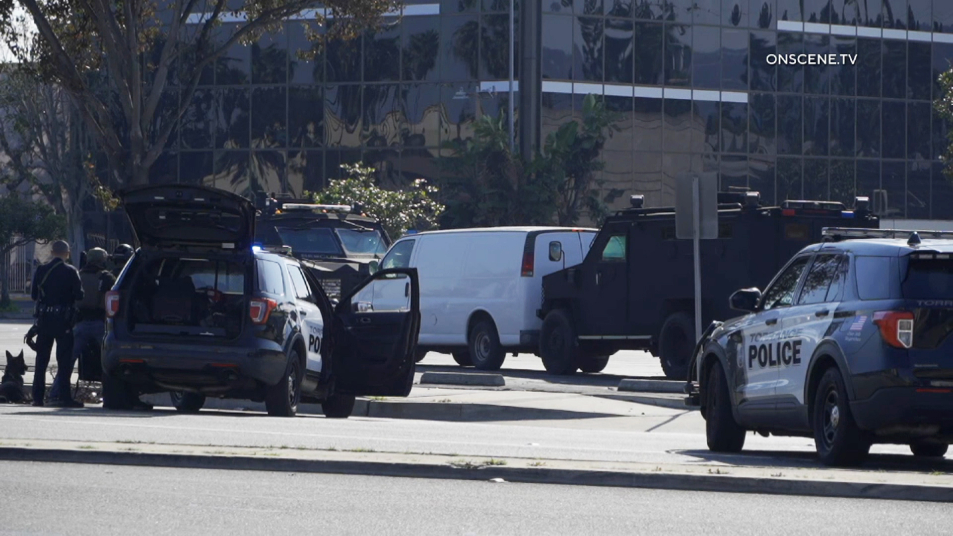 Police vehicles surround a white van during a standoff in Torrence, California, Sunday. 